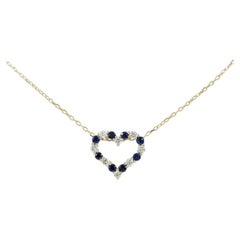 Collar con colgante de corazón abierto de oro amarillo de 14K con zafiros y diamantes