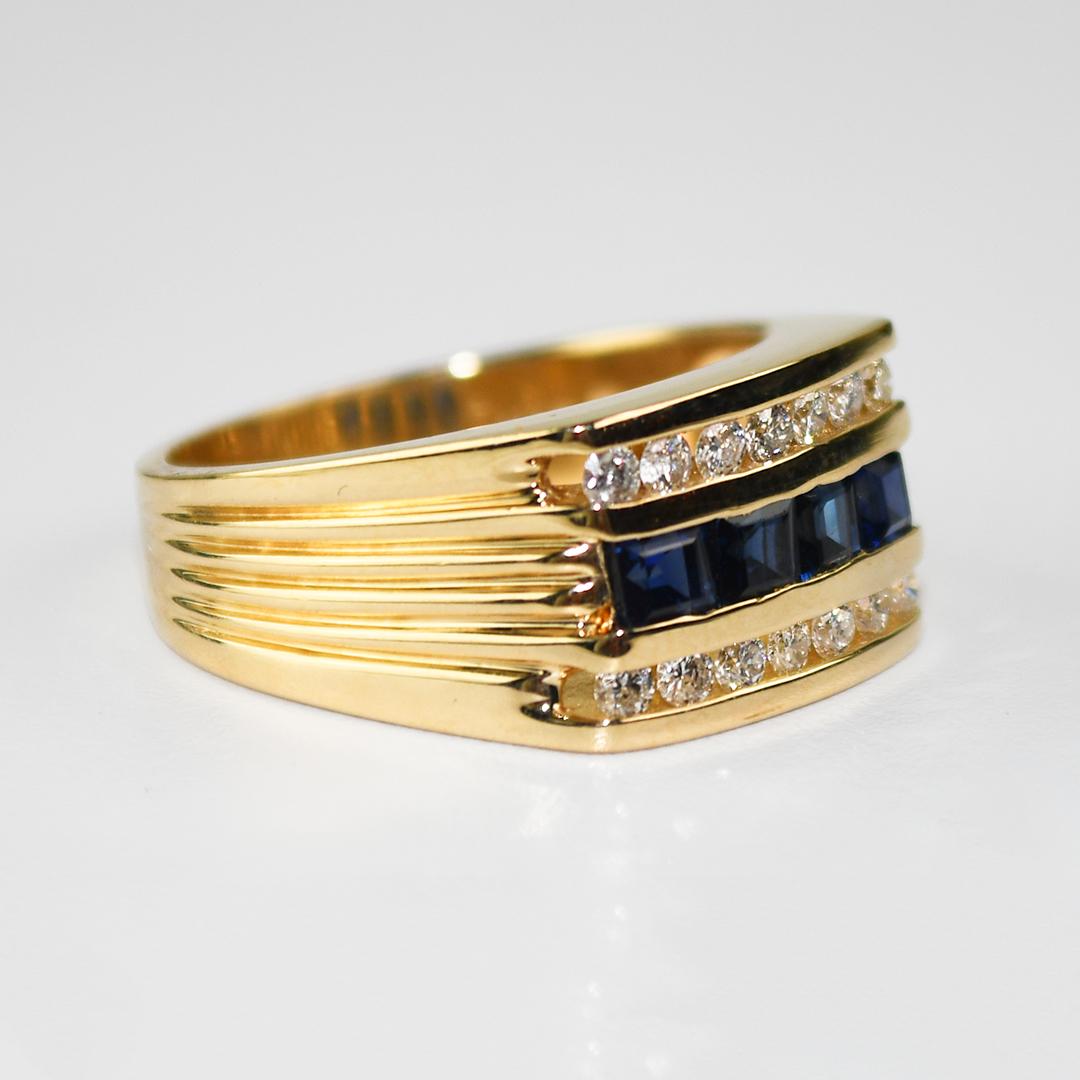 Herrenring aus 14k Gelbgold mit Saphiren und Diamanten.
Gestempelt 14k und wiegt 8,5 Gramm.
Die natürlichen Saphire sind quadratisch, stufenförmig geschliffen, von dunkelblauer Farbe und haben insgesamt 0,50 Karat.
Die seitlichen Diamanten sind