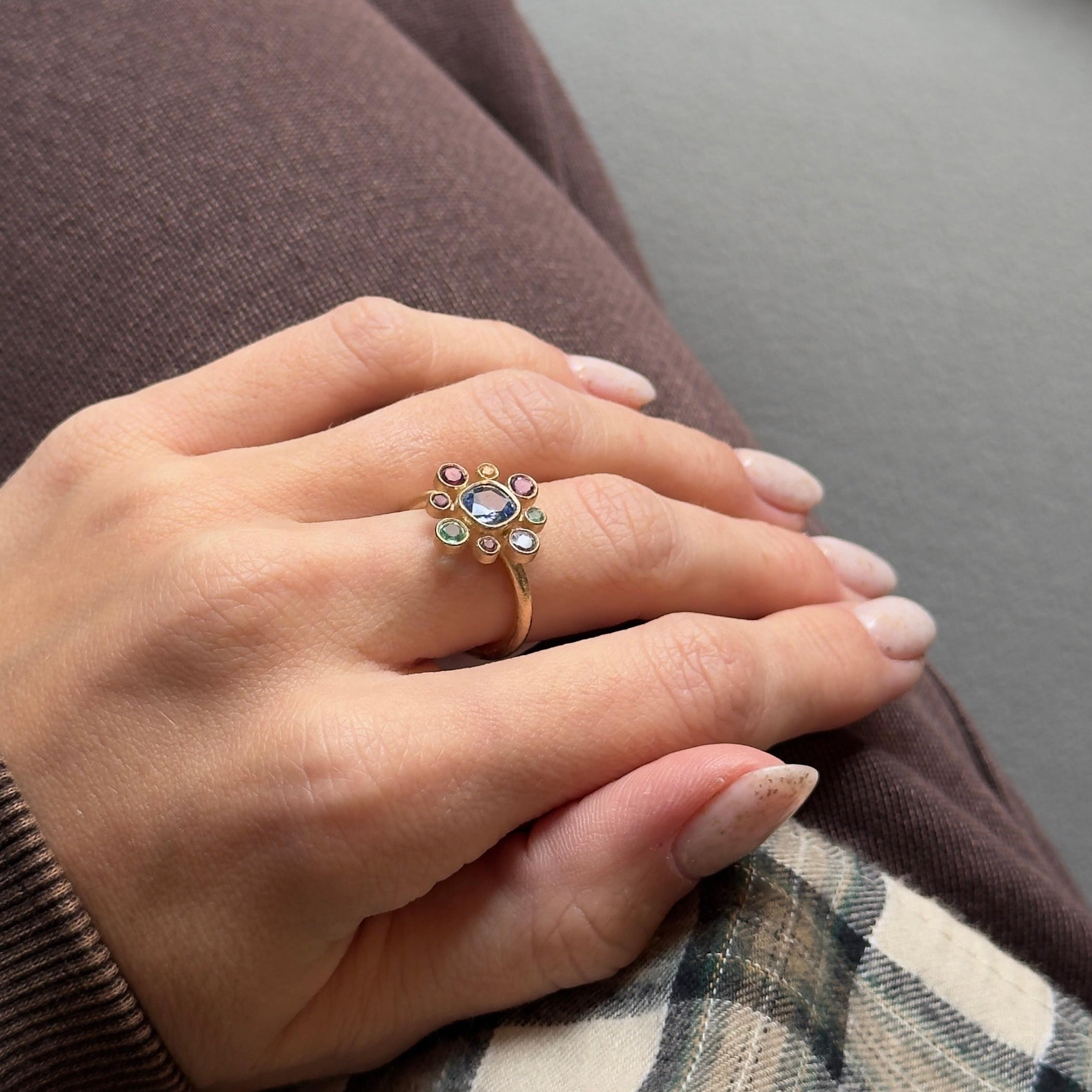 Époque : New
Composition : Or jaune 14K
Pierre principale : Saphir bleu naturel taille coussin
Poids en carats : 1,16 carats
Pierres d'accentuation : Huit pierres naturelles multicolores
Poids en carats : 0,66 carats au total
Taille de l'anneau :