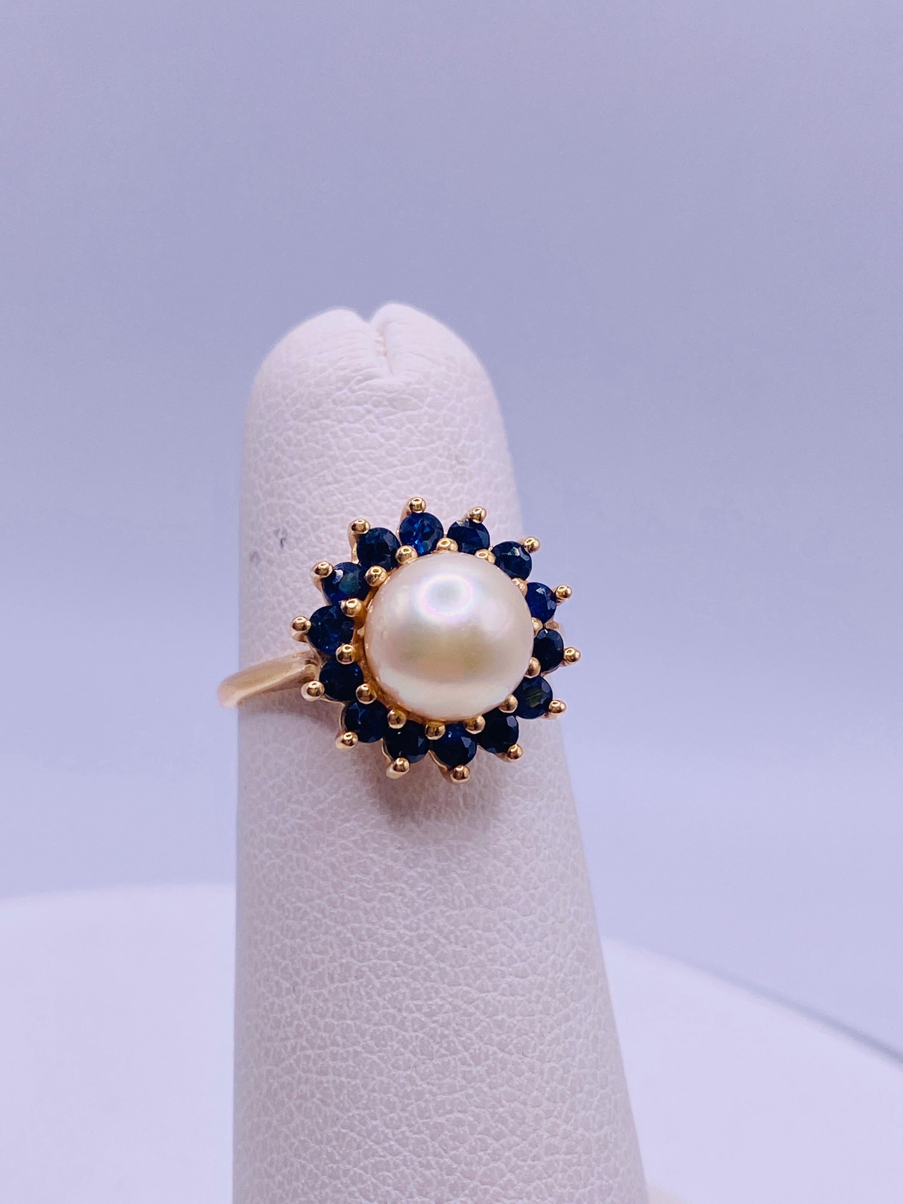 14k yellow gold ring with center cultured pearl and 14 round cut sapphires surrounding. 2.1dwt.