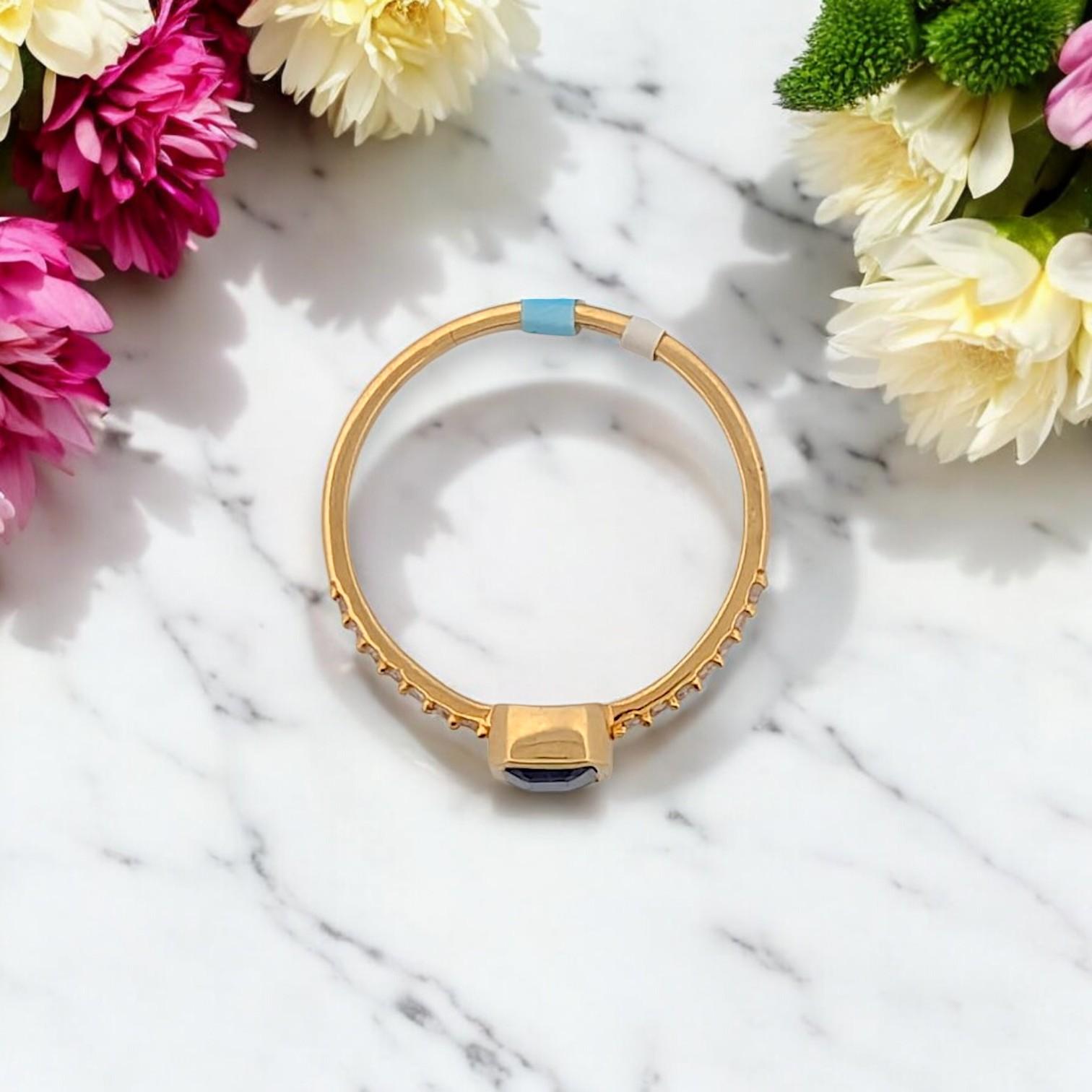 Crafted in rich 14K yellow gold, this refined ring features a striking 1.10 CT emerald cut natural Sapphire, known for its deep, royal blue hue. Framed with .10 CTW round natural Diamonds, the design blends classic elegance with modern simplicity. A