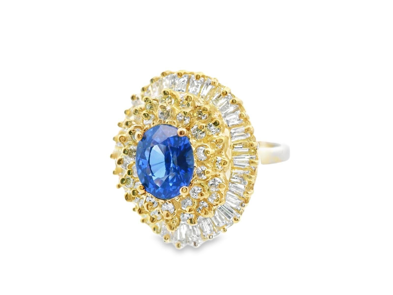 This incredible ring is made in 14k yellow gold with a rich blue sapphire and sparkly white diamonds. The center of the ring features a 1.92 carat oval sapphire with a deep blue hue. The sapphire is surrounded by 2 rows of round cut diamonds that is