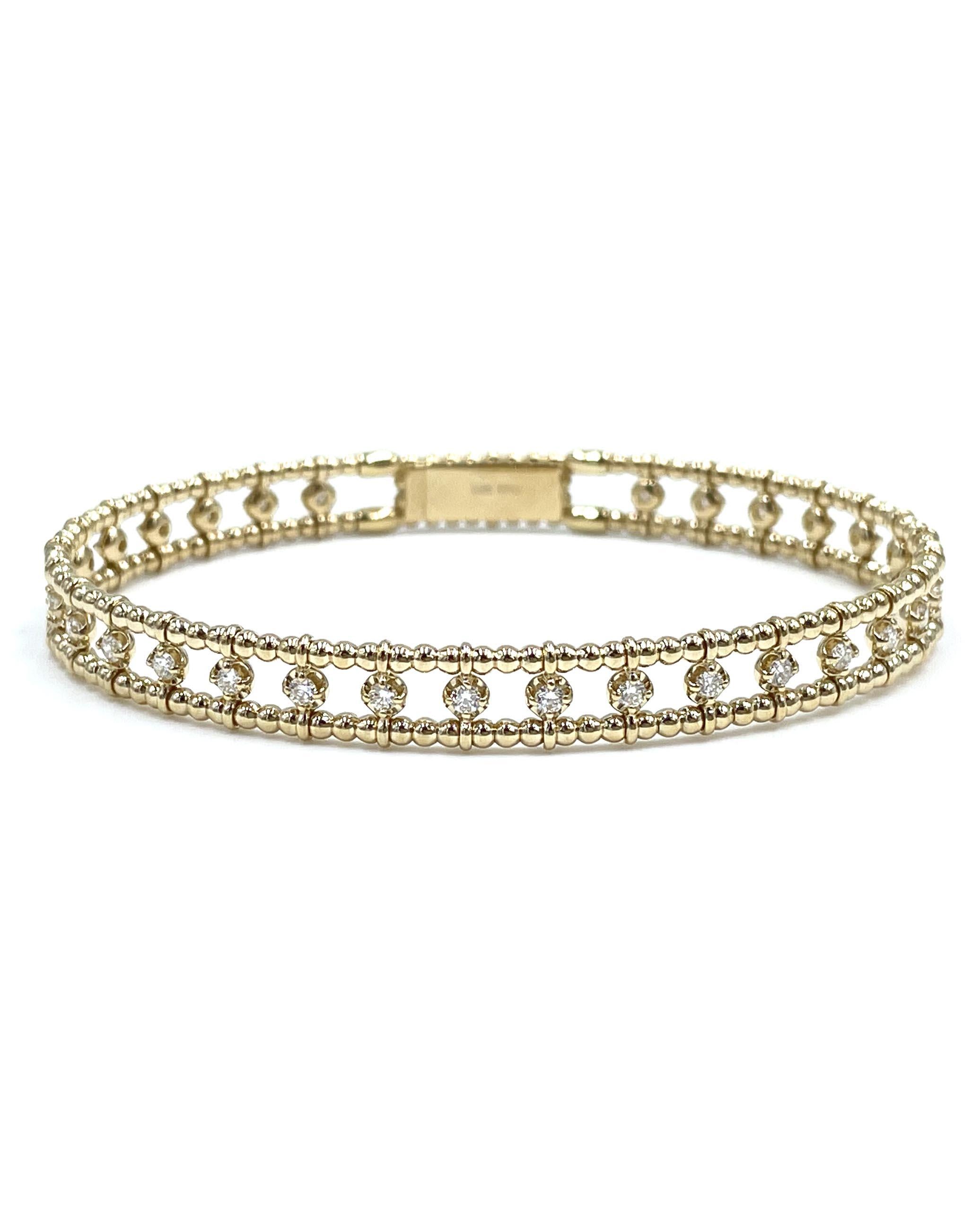 14K yellow gold semi diamond bangle. The bangle features a beaded border and is furnished with 32 round brilliant-cut diamonds weighing 0.75 carats total. 

- 6.6mm wide.
- Diamonds are G color, VS clarity.
- 6.5 inches.