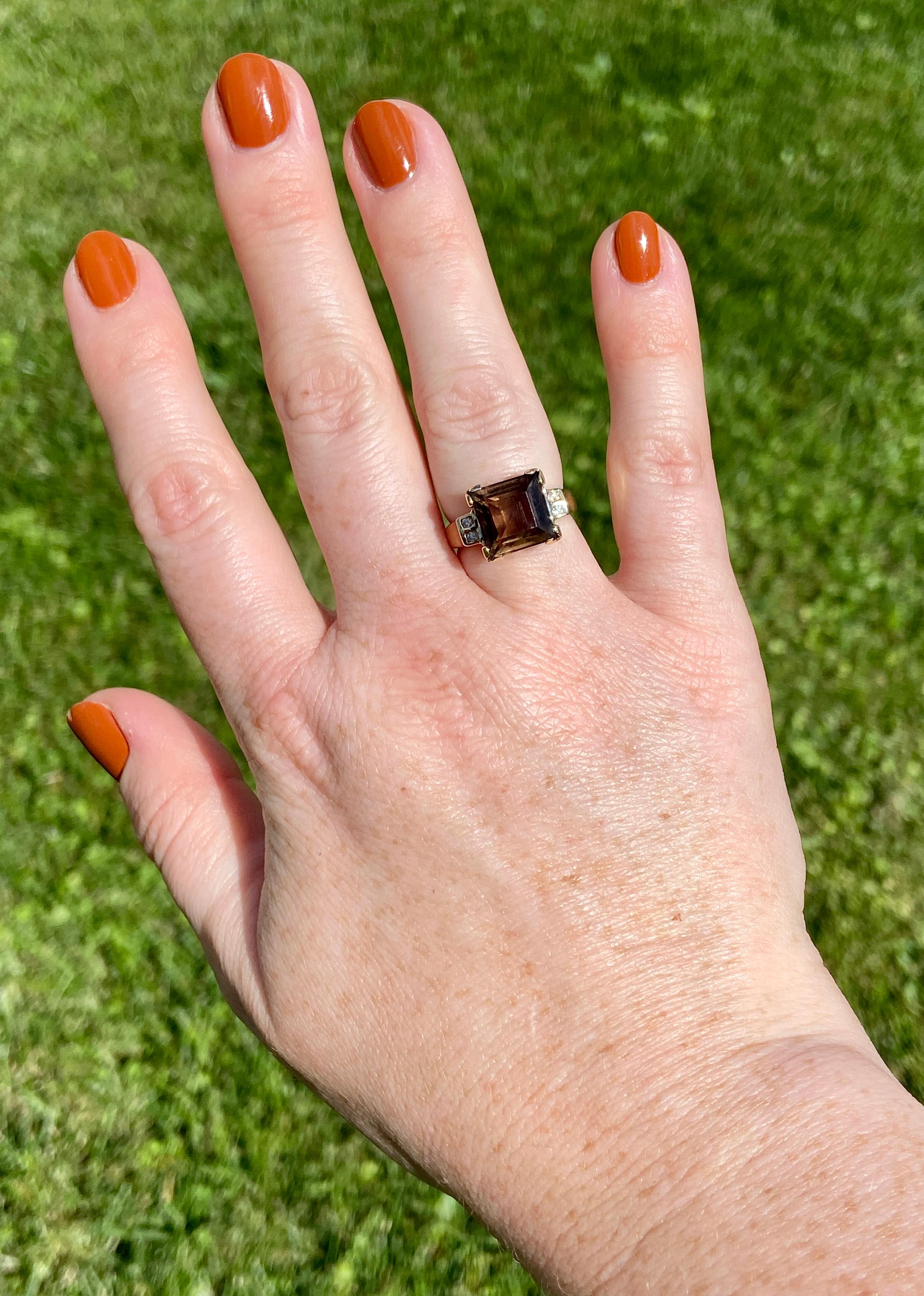 Delectable smoky quartz, the chocolatey sibling to other popular quartz varieties of amethyst and citrine, is the 3.81ct centerpiece of this vintage ring. The bold step-cut stone is set in v-prongs and is accented on each side with two diamonds, all