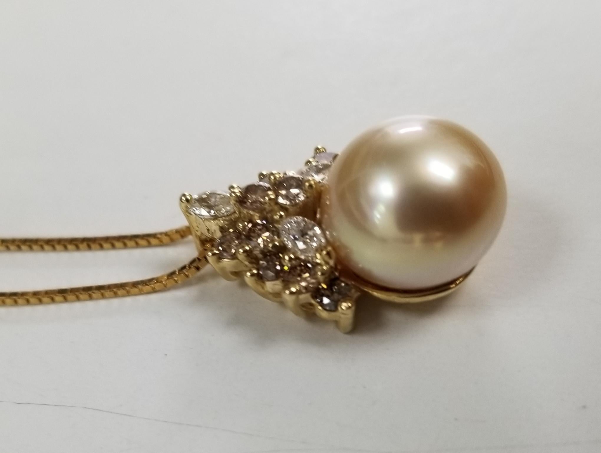 14k yellow gold South Sea Golden Pearl with brown and white diamonds, containing 1-11.06mm South Sea Golden Pearl with 3 white diamonds weighing .32pts. and 12 brown diamonds weighing .75pts. on a 18 inch box chain. 