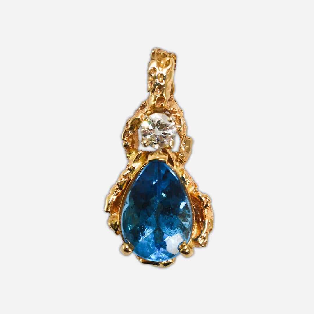  Swiss blue topaz and diamond necklace in 14k yellow gold.
Tests 14k and weighs 8.8 grams.
The blue topaz has excellent color, is pear-shaped, and measures 13.2mm by 8.75mm.
On the top of the pendant is an old Euro cut diamond, .33 carat, H color,