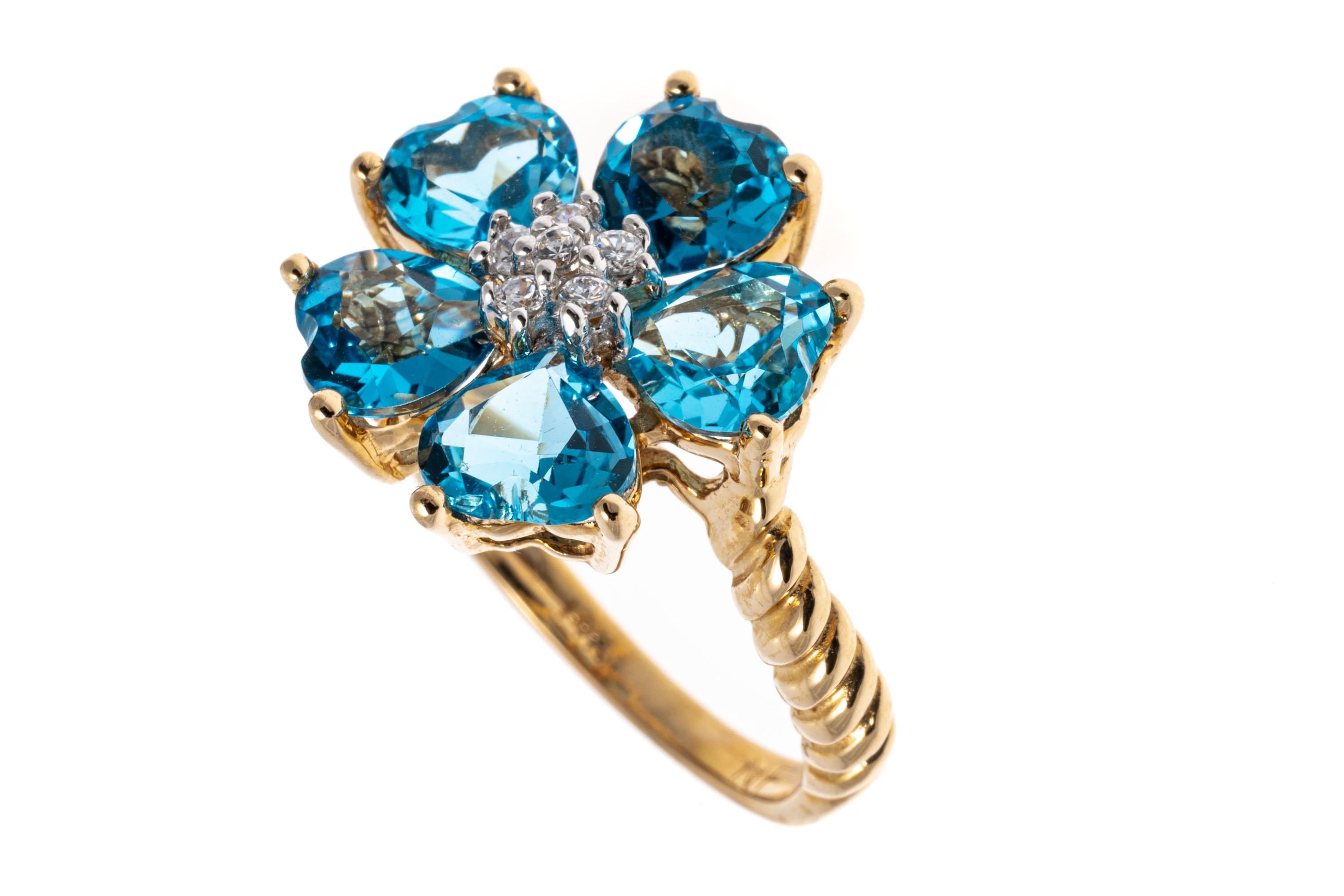 14k yellow gold ring. This cheerful ring has a cluster of heart shaped faceted, Swiss blue color blue topaz, set into a flower form, approximately 2.25 TCW, prong set, and decorated with a center cluster of round brilliant cut  cz stones, also prong