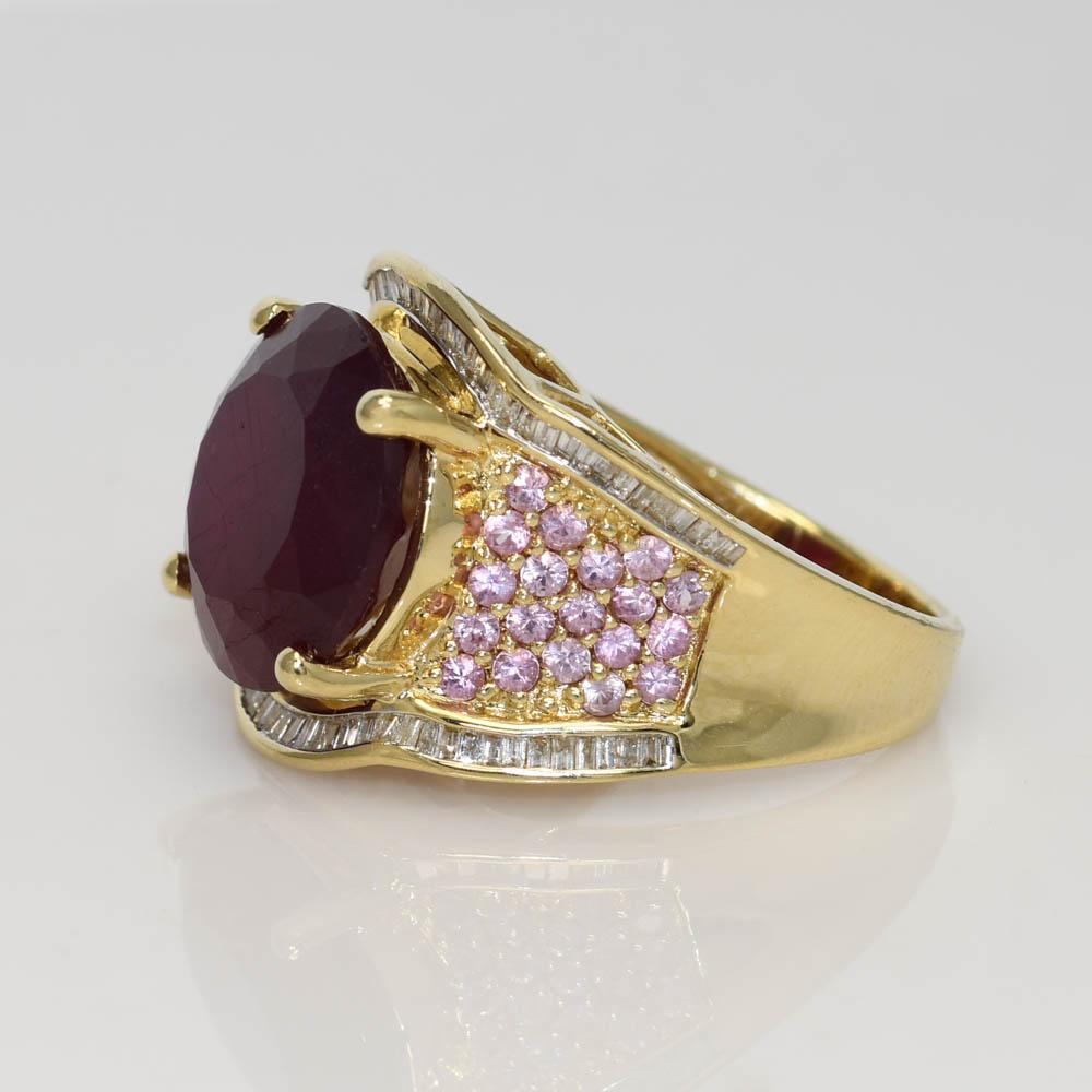 Ladies lab grown ruby ring with diamonds and pink topaz in 14k yellow gold setting.
Stamped 14k and weighs 10.5 grams gross weight.
The center stone is a round brilliant cut, lab grown ruby, 11.50 carats.
The stone is a dark red and the clarity is