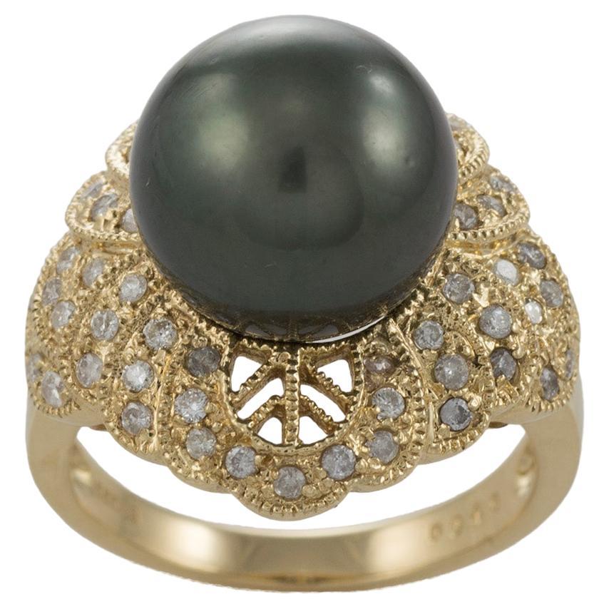 Tahitian pearl and diamond Ring.
Marked .585 and weighs 9 grams.
The pearl is a 12mm dark grey Tahitian with light green overtones.
On the sides are small round diamonds, .50 carats total weight, h color, i1 clarity.
The diamonds are set in