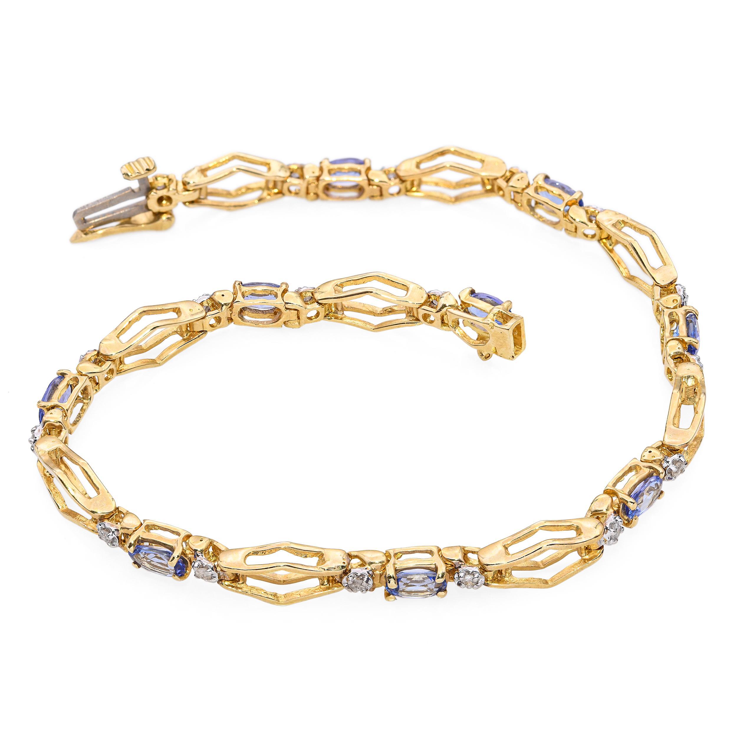 Ce bracelet de tennis en or jaune 14k présente une belle combinaison de tanzanites et de diamants, créant un équilibre raffiné de couleurs et d'éclat. Les tanzanites présentent une douce teinte bleu-violet qui contraste élégamment avec la brillance