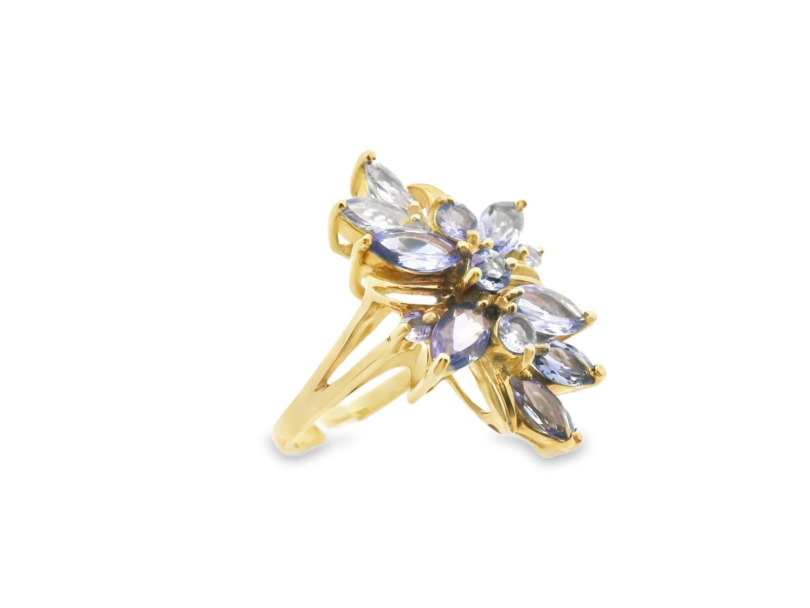Dieser lustige Ring ist aus 14-karätigem Gelbgold gefertigt und zeigt eine schöne Mischung aus runden und marquisen Tansaniten. Das Muster des Tansanits erinnert an eine Blume oder eine Weinrebe, und die Anordnung erfolgt in Nord-Süd-Richtung auf