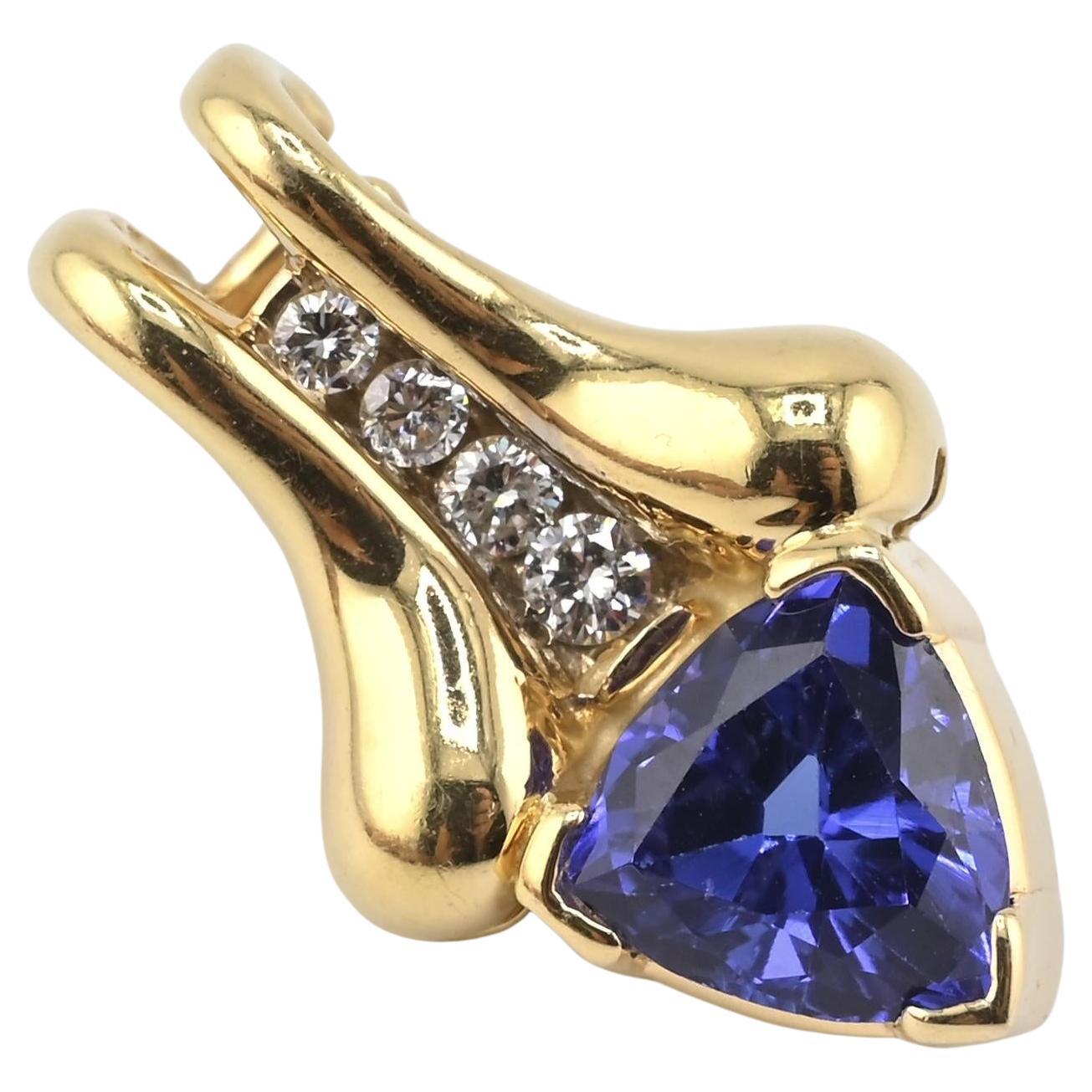 Magnifique pendentif en or jaune 14K Tanzanite et diamant présentant une tanzanite naturelle de taille trillion d'une riche couleur bleu-violet. La pierre précieuse est rehaussée d'une rangée de diamants naturels étincelants sertis dans un design
