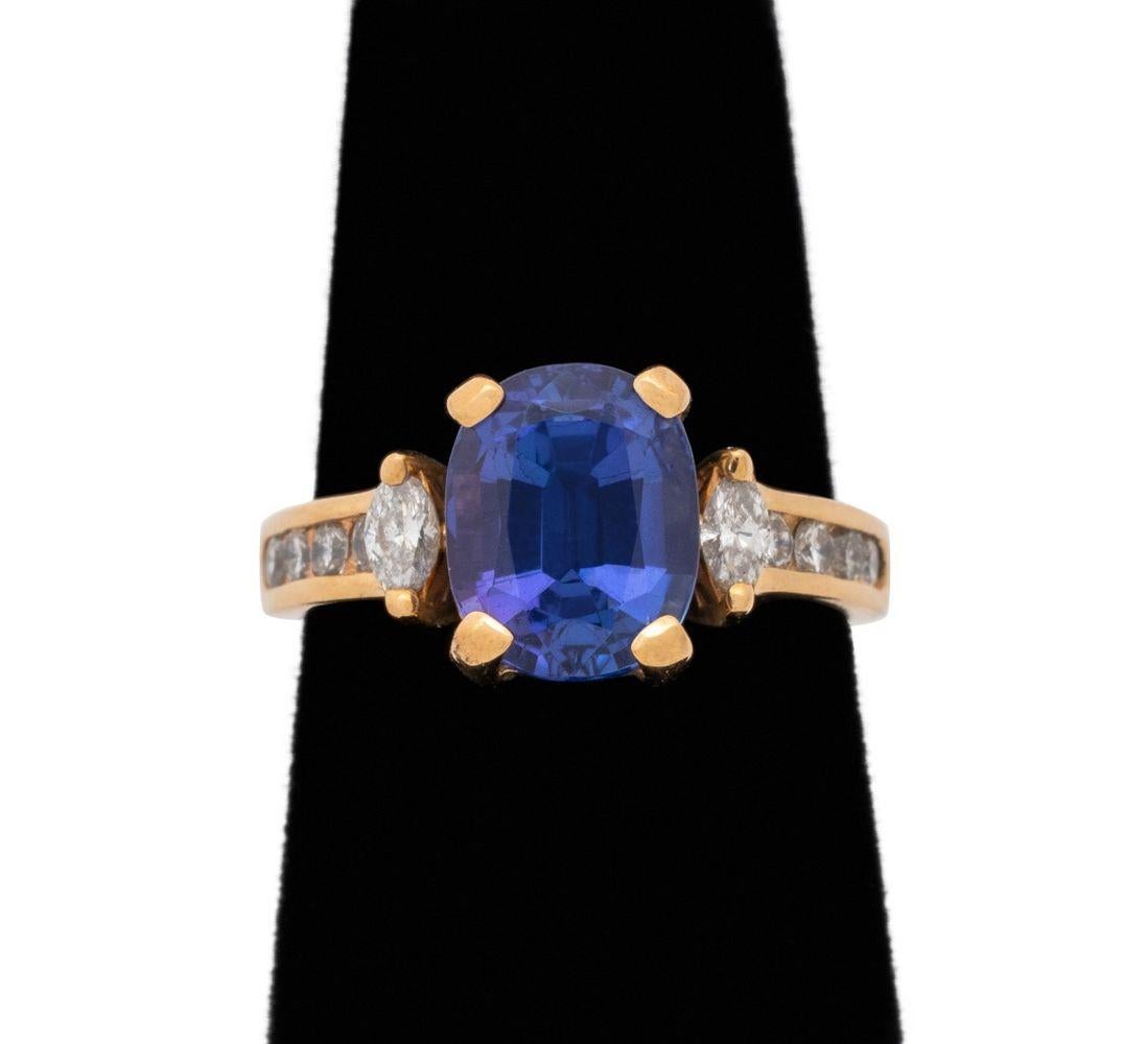 Bague en or jaune 14K Tanzanite diamantée, présentant une tanzanite coussin brillante en serti clos pesant 2,50 carats, également ornée de 2 diamants marquise de taille brillant en serti clos et de 8 diamants ronds de taille brillant en serti clos