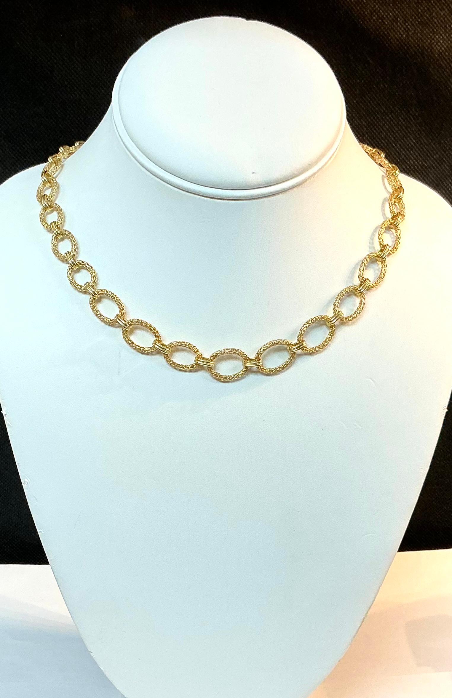 Mid-20th Century 14K Yellow Gold Oval Link Necklace. Necklace features a continuous series of textured oval links, each intricately finished to catch and reflect light with a subtle shimmer.  The links are uniformly sized and connected with delicate