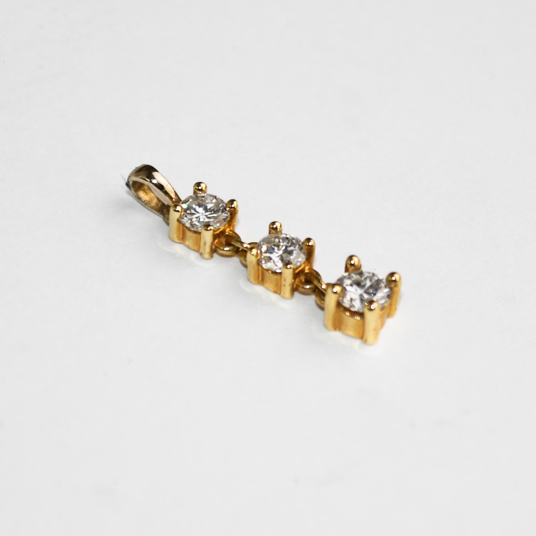 Ce magnifique pendentif en or jaune 14 carats à trois pierres pèse 1,4 gramme.
Il contient trois diamants ronds de taille brillant, les deux diamants supérieurs ont un poids en carats de 0,20 et le diamant inférieur a un poids en carats de 0,25.
Les