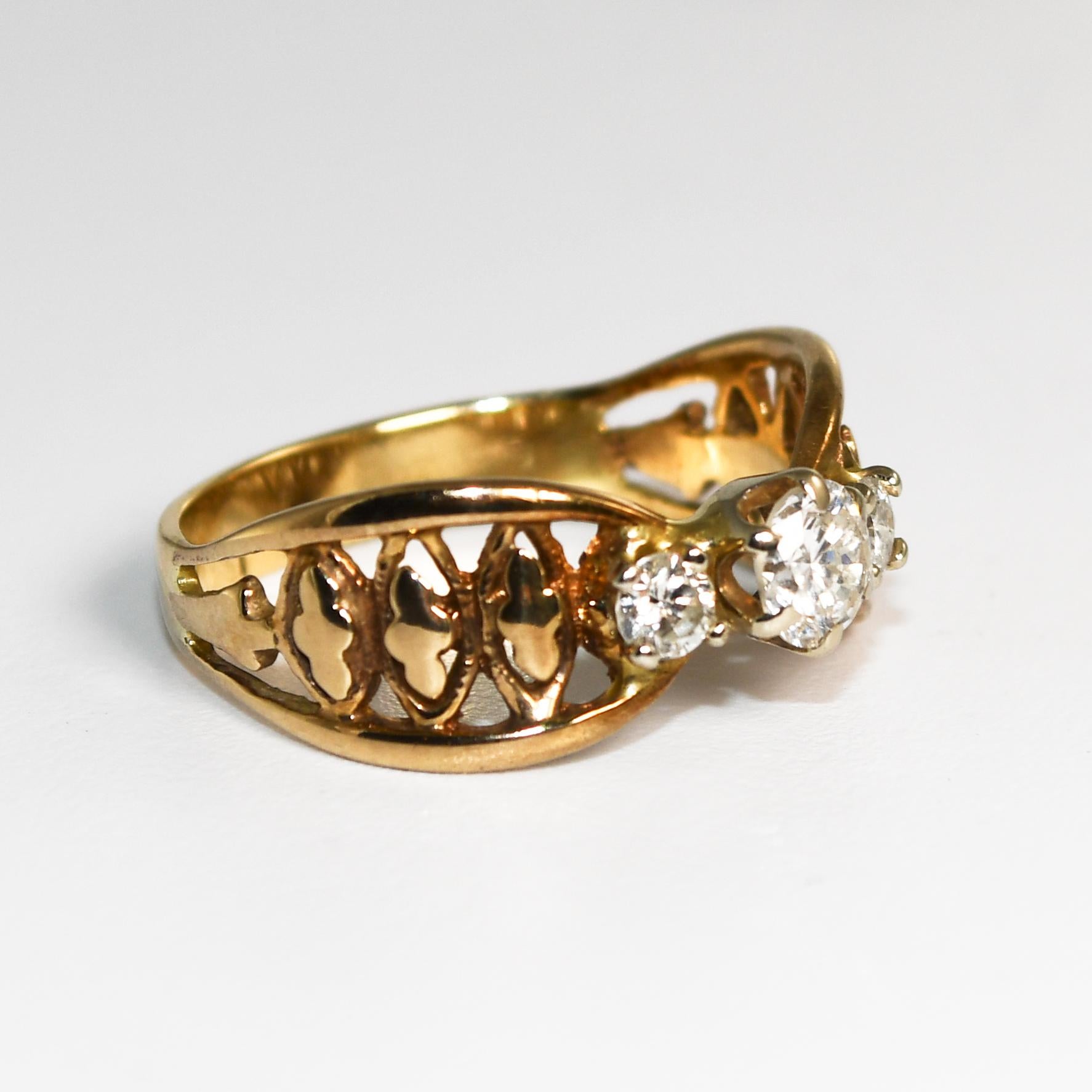 Bague à trois diamants en or jaune 14k.
Le diamant central est  un diamant rond de 0,35 carat, de couleur I-J-K et de pureté Vs1-VS2.
Les deux diamants latéraux sont des brillants ronds, .20 carats au total, couleur H-I-J, pureté I1-I2.
Testé en 14k