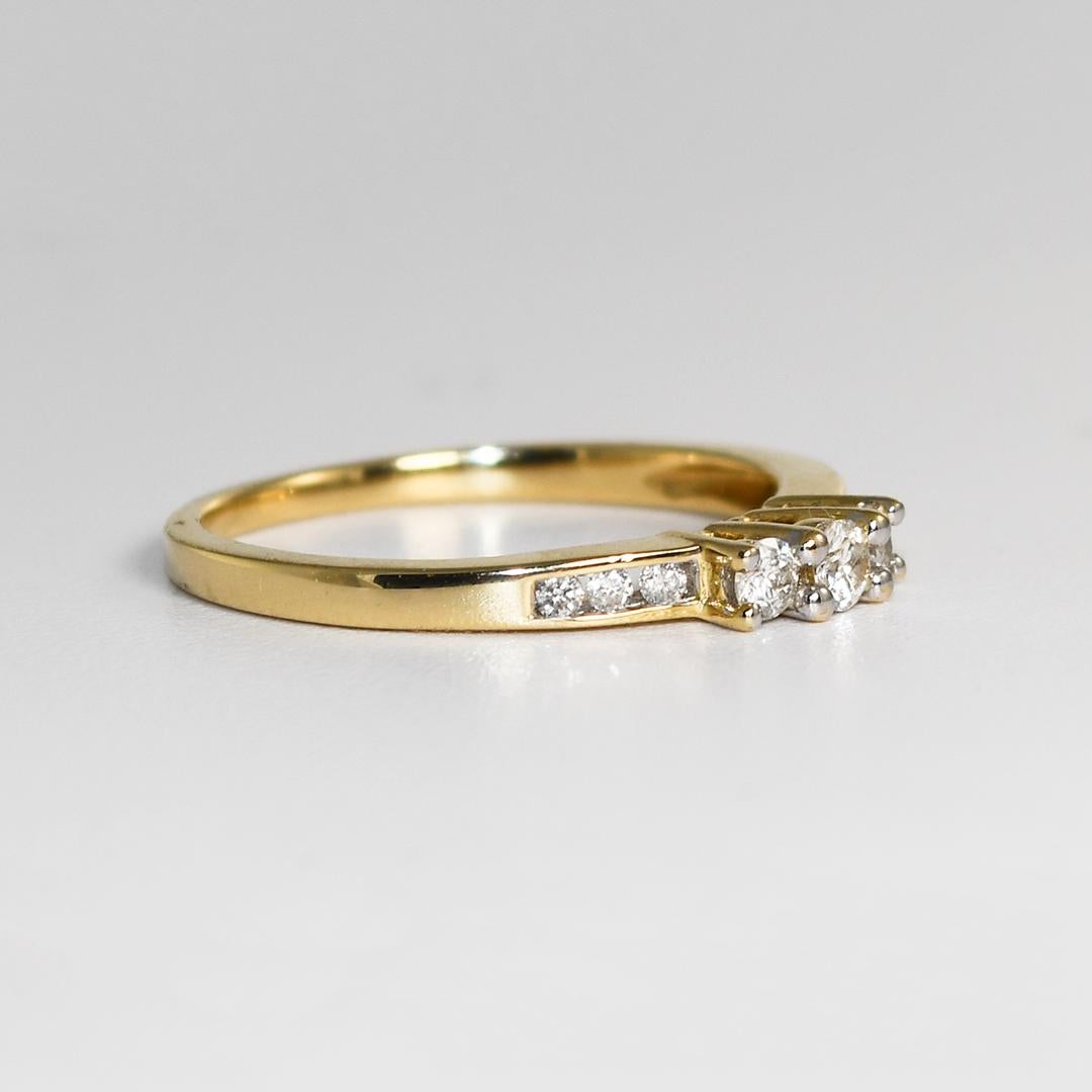 This is a 14k yellow gold three-stone natural Diamond ring with accent diamonds.
The main three stones have approximately a total diamond weight of 0.30 carats mounted in 4-prong settings.
The three stones have SI2 clarity and H color.
There are 6