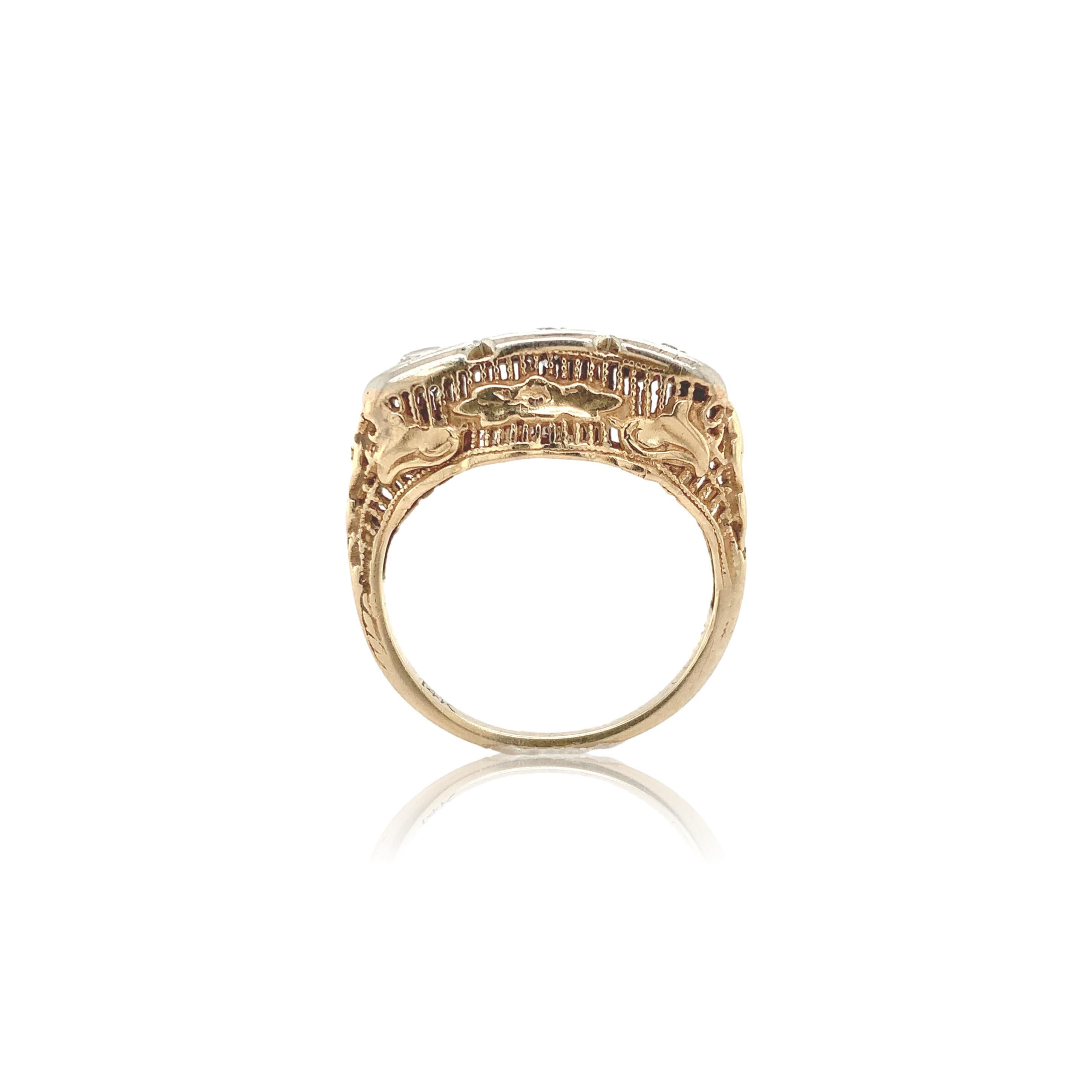 14K Yellow gold filigree ring with three diamonds set in white gold. The diamonds are round brilliant cut and measure about 3.3mm. Total diamond weight is approximately .45ct. The ring fits a size 5 finger and weighs 1.97dwt. It dates from the