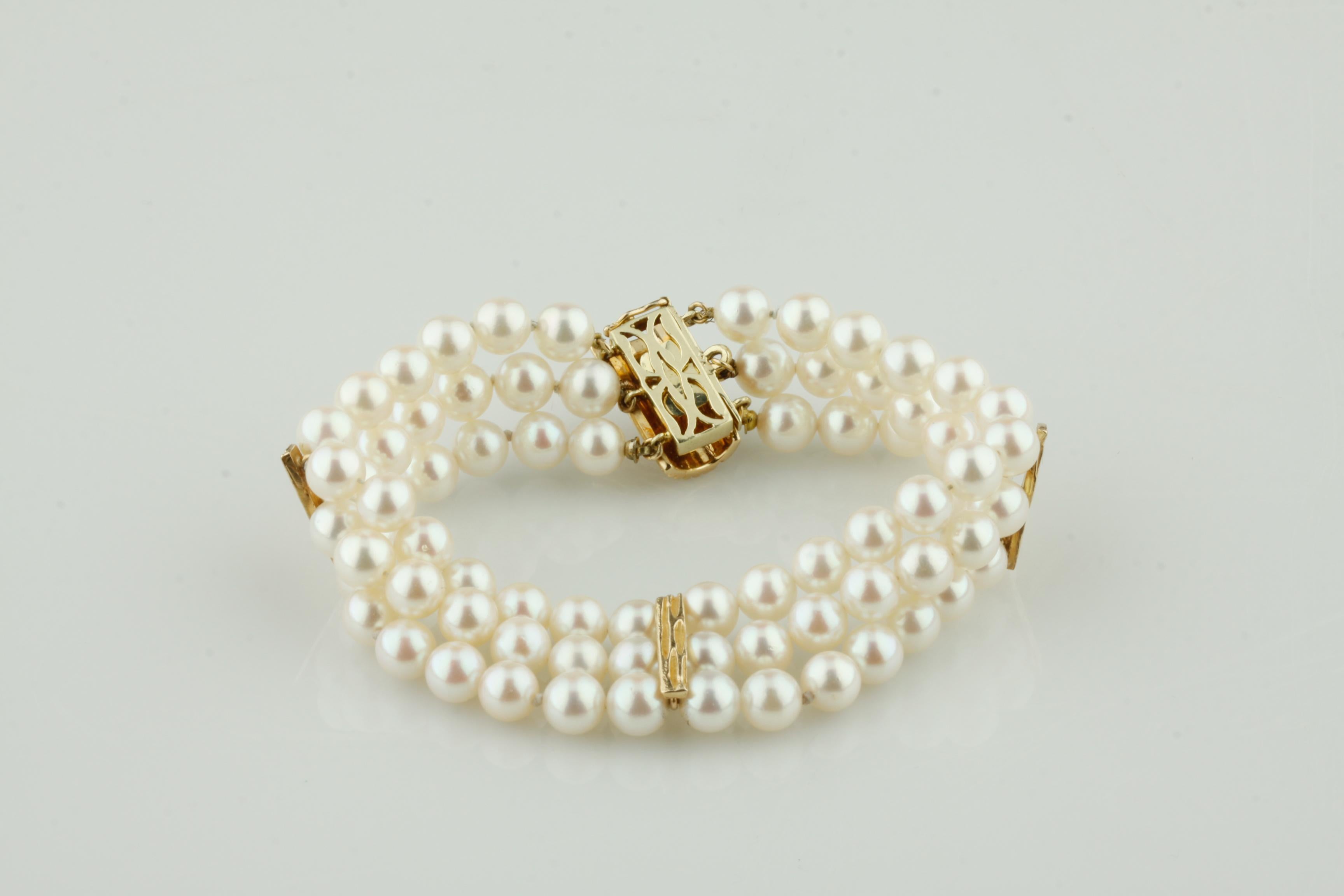 Magnifique bracelet de perles 
Comprend trois rangs de perles rondes
Perles d'environ 5 à 6 mm de diamètre
Belle perlescence blanchâtre, rosâtre et mauve.
78 Perles Total
Trois accents en forme de barre en or jaune 14k
Fermoir en or jaune