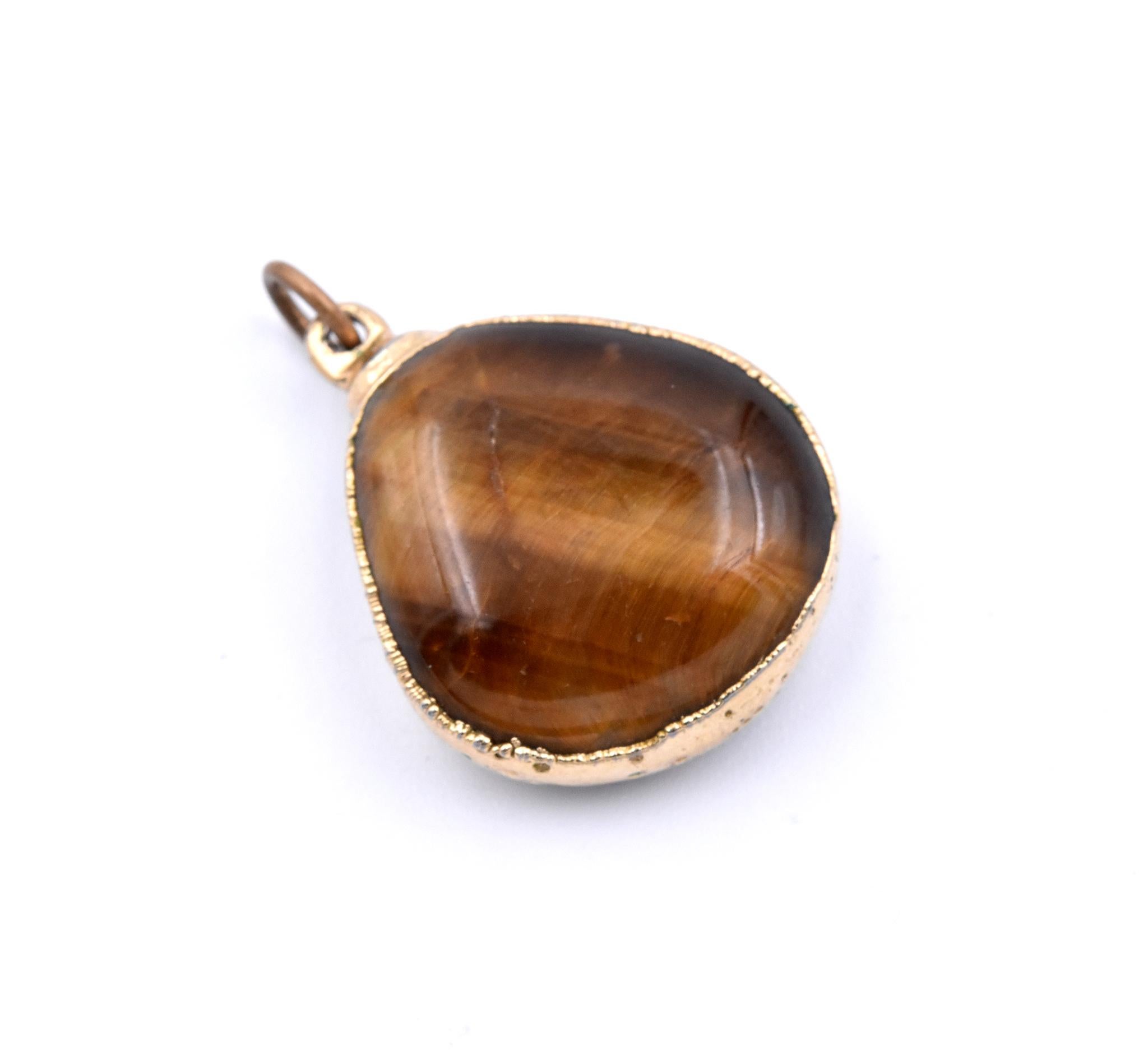 Designer: Custom Design
Material: 14k yellow gold and tiger’s eye
Dimensions: the pendant measures 19.55mm x 27.70mm
Weight: 5.3 grams	
