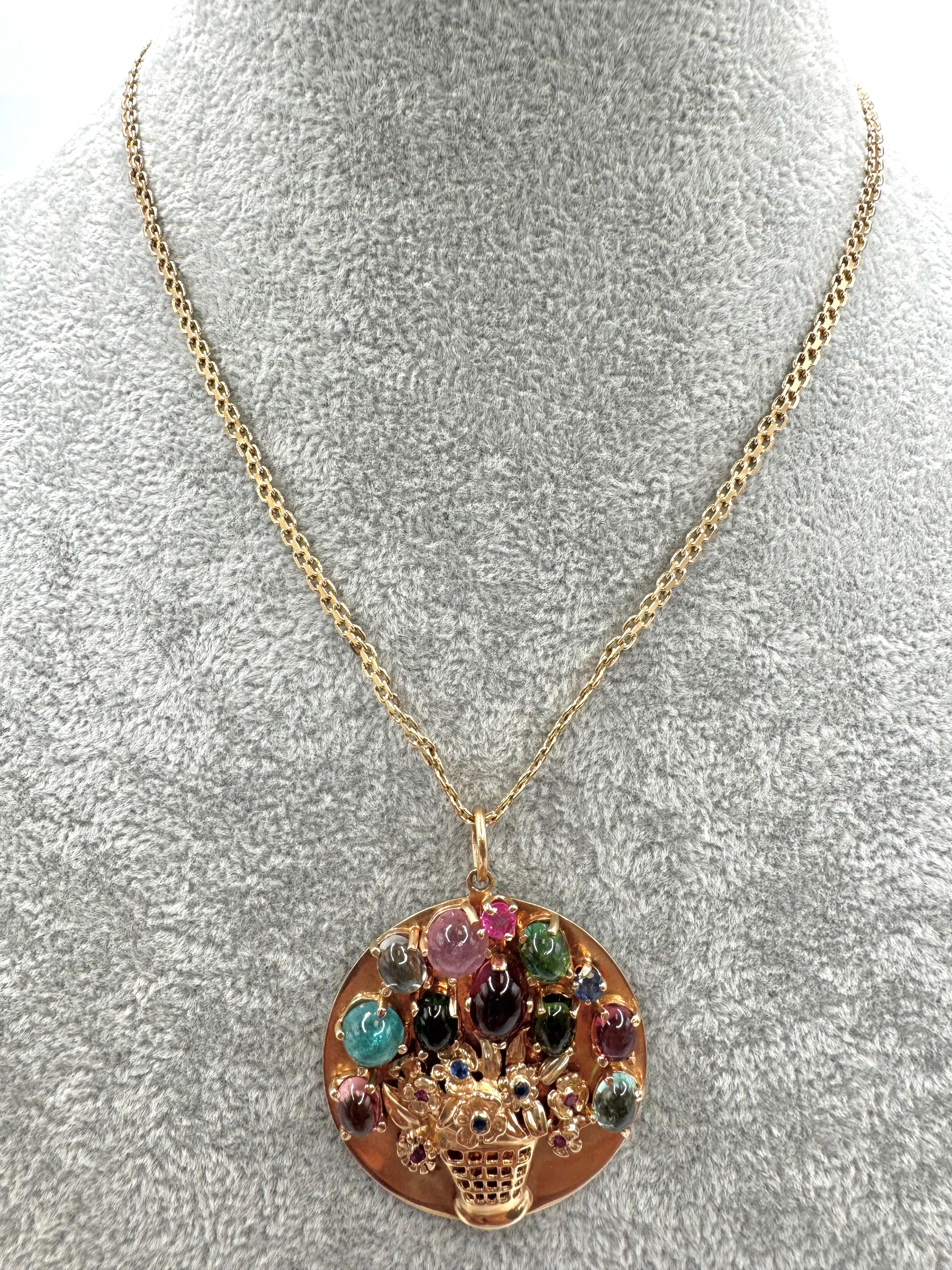 A vibrant expression of Italian artistry, this vintage 14K yellow gold necklace features a striking round pendant designed as a basket overflowing with gemstone flowers. The three-dimensional floral motif showcases ten richly hued tourmalines