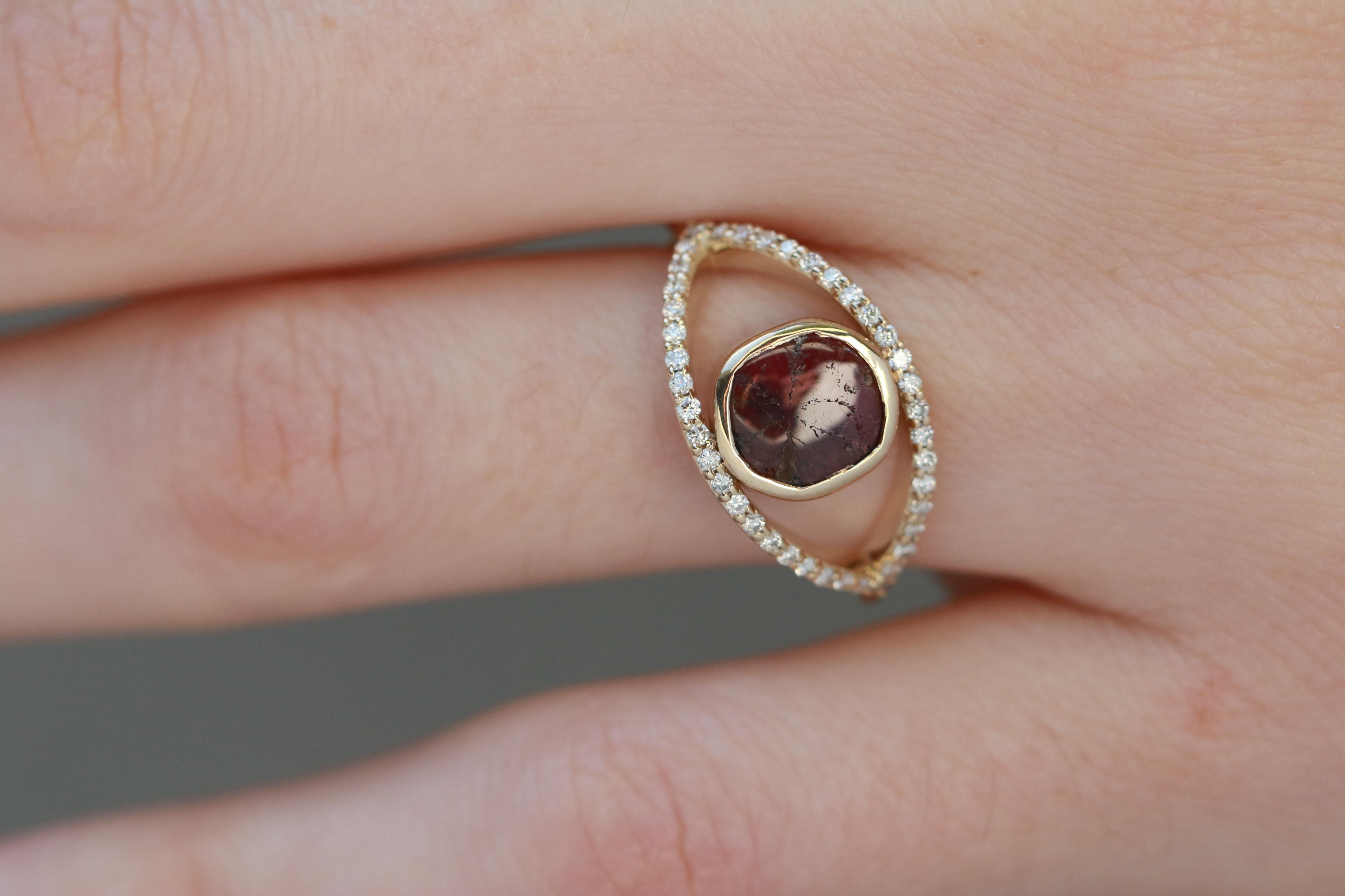 A trapiche ruby with its hallmark starburst pattern is surrounded by an eye marquis shaped ring, accented by 40 brilliant white diamonds. 

Stones:
Trapiche ruby slice, ~6mm
40 1mm full cut round white diamonds