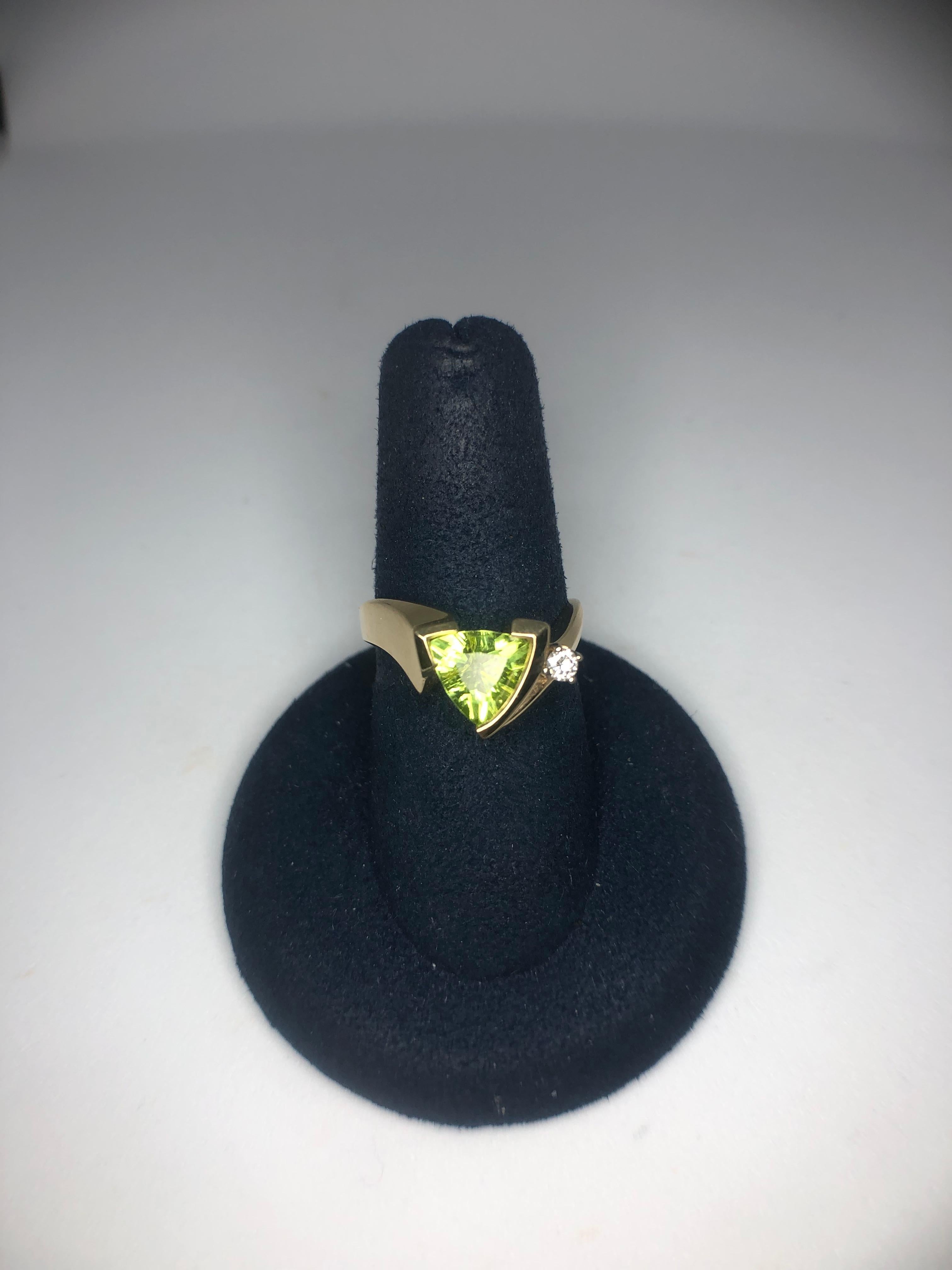 Lady's 14kt yellow gold trillion cut peridot and diamond ring by Aurum, 1 - trillion cut peridot = 1.25ct, 1 - diamond = .07ct. Style #A-125. Size 6.