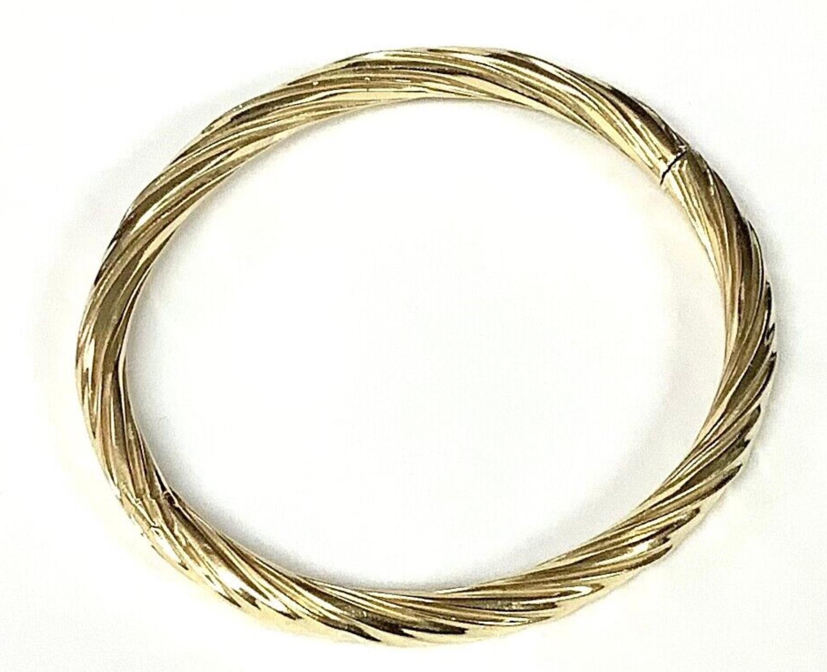 14k yellow gold women's twist bangle bracelet. This timeless bangle bracelet is made of 14 karat yellow gold. It has a wonderful warm glow. The bracelet has a nice height of 5 millimeters, is oval shaped and hinged. This lovely bangle is versatile