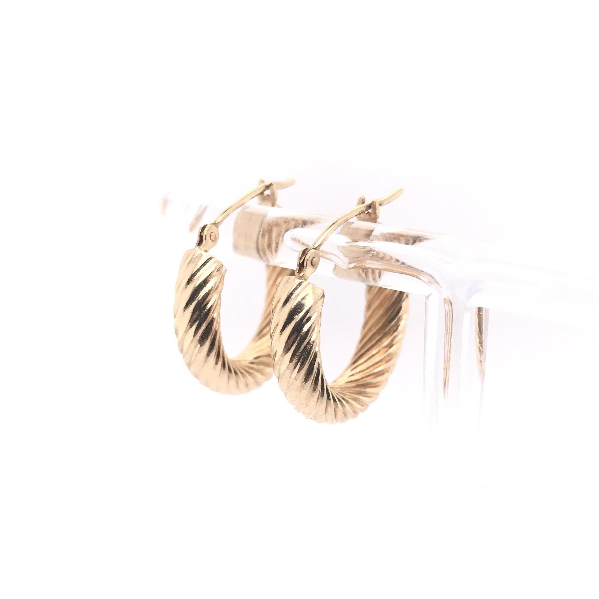 These hoop earrings are a contemporary piece and have never been worn. These 14k gold hoop earrings measure approximately 3/4s of an inch in length and feature a stylish twist motif. The earrings are sturdy but hollow allowing for a very comfortable