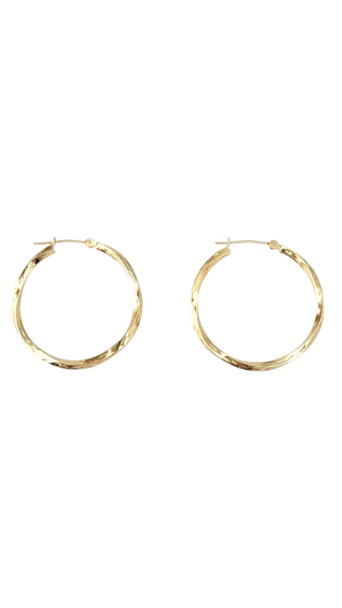 14K Yellow Gold Twisted Hoop Earrings 

These 18K yellow gold twisted hoop earrings feature an elegant, spiral design that adds texture and sophistication to a classic hoop shape. The rich gold tone enhances their luxurious appeal, making them a