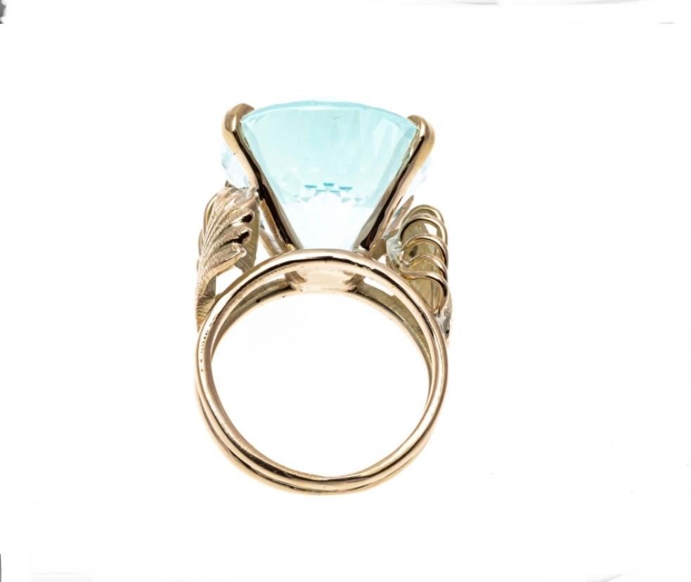 Boasting approximately 22 cts., this striking aquamarine stone displays soft blue tones and is prong set into a 14K yellow gold ring. The ring has a delicate wing like design wrapping around the shanks. Ring size 5.5
Marks: Unmarked, tested as