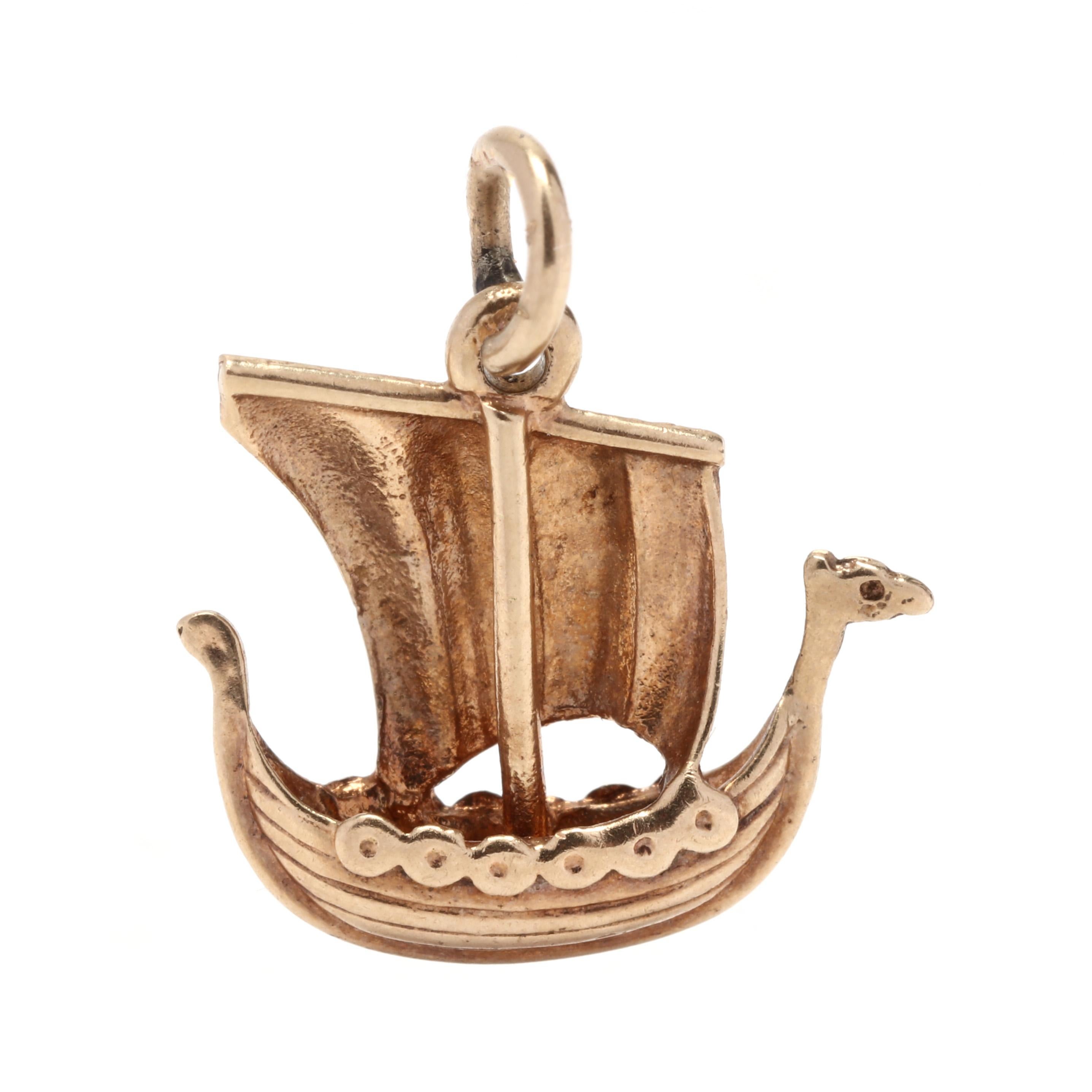 A vintage 14 karat yellow gold viking ship charm. This charm features a wooden viking ship motif with a large sail and a round jump ring / bail.



Length: 5/8 in.



Width: 5/8 in.



Weight: 1 dwt.