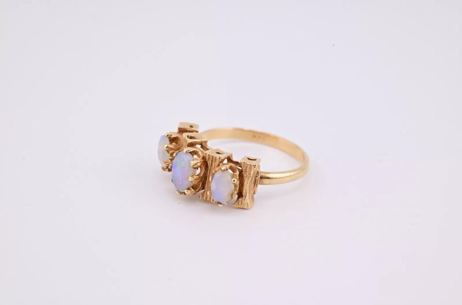 This is a gorgeous 14 karat yellow gold opal ring. There are three gorgeous white opals with a decent amount of fire. It has a unique intricate design. The weight of the ring is 2.78 grams and the ring size is 5 1/2. The condition is excellent. It