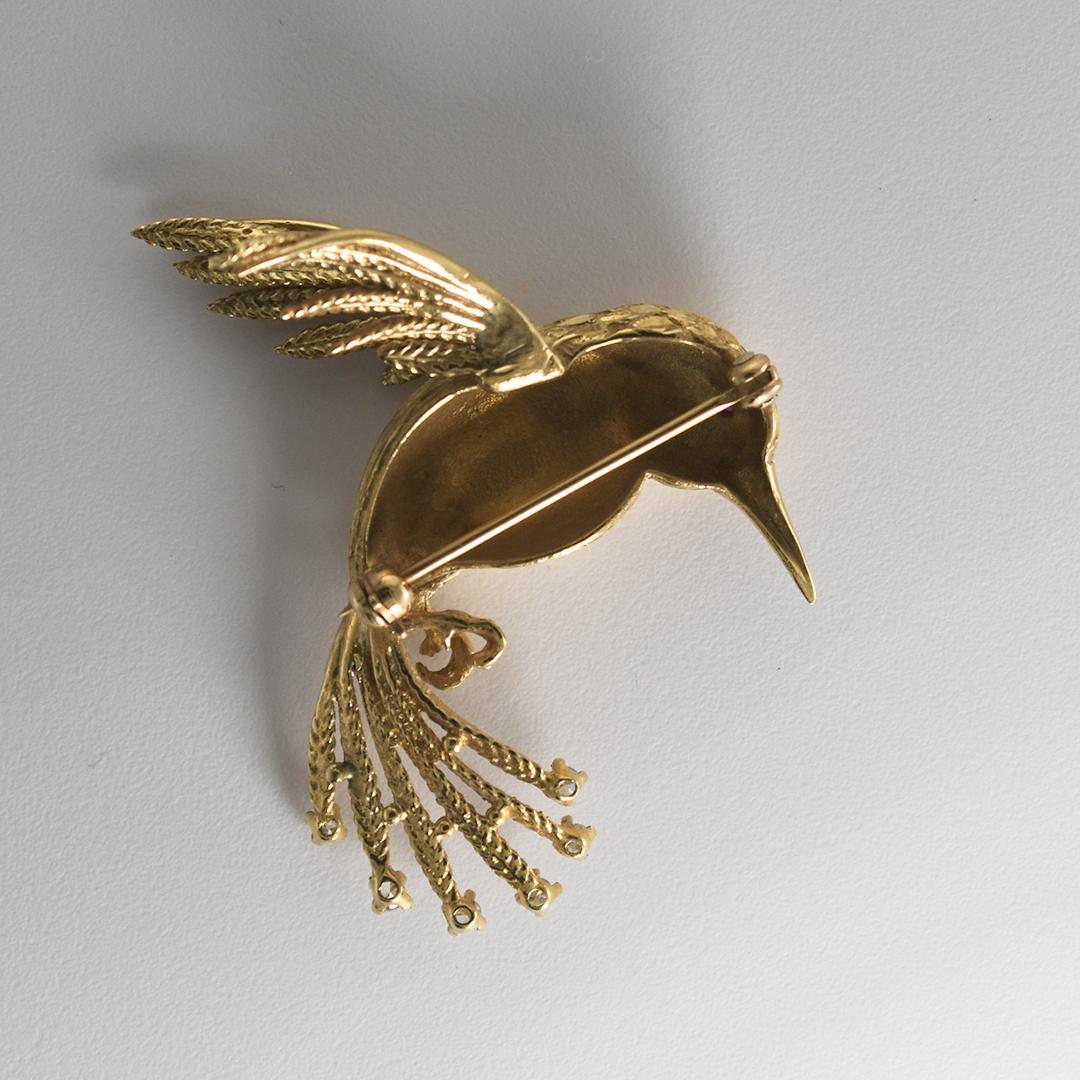 Vintage 14k yellow gold hummingbird brooch.
Tests 57% gold, using a XRF metals analyzer.
The brooch weighs 12.4 grams.
There are six, single-cut diamonds on the tail, .15 total carats.
Attractive textured finish on the hummingbird.
The brooch