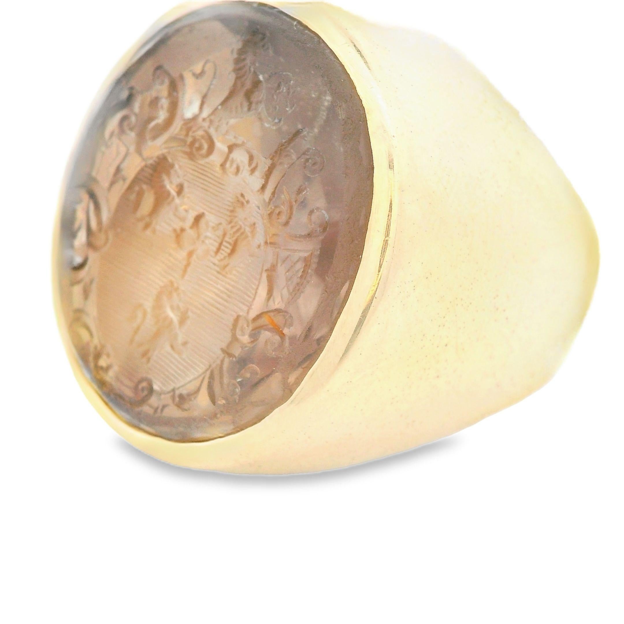 This large seal ring is made in 14k yellow gold and features a transparent quartz that has been engraved with a family seal. The ring is quite large and hefty, and makes you feel like you are holding a solid block of gold on your finger. Wearing