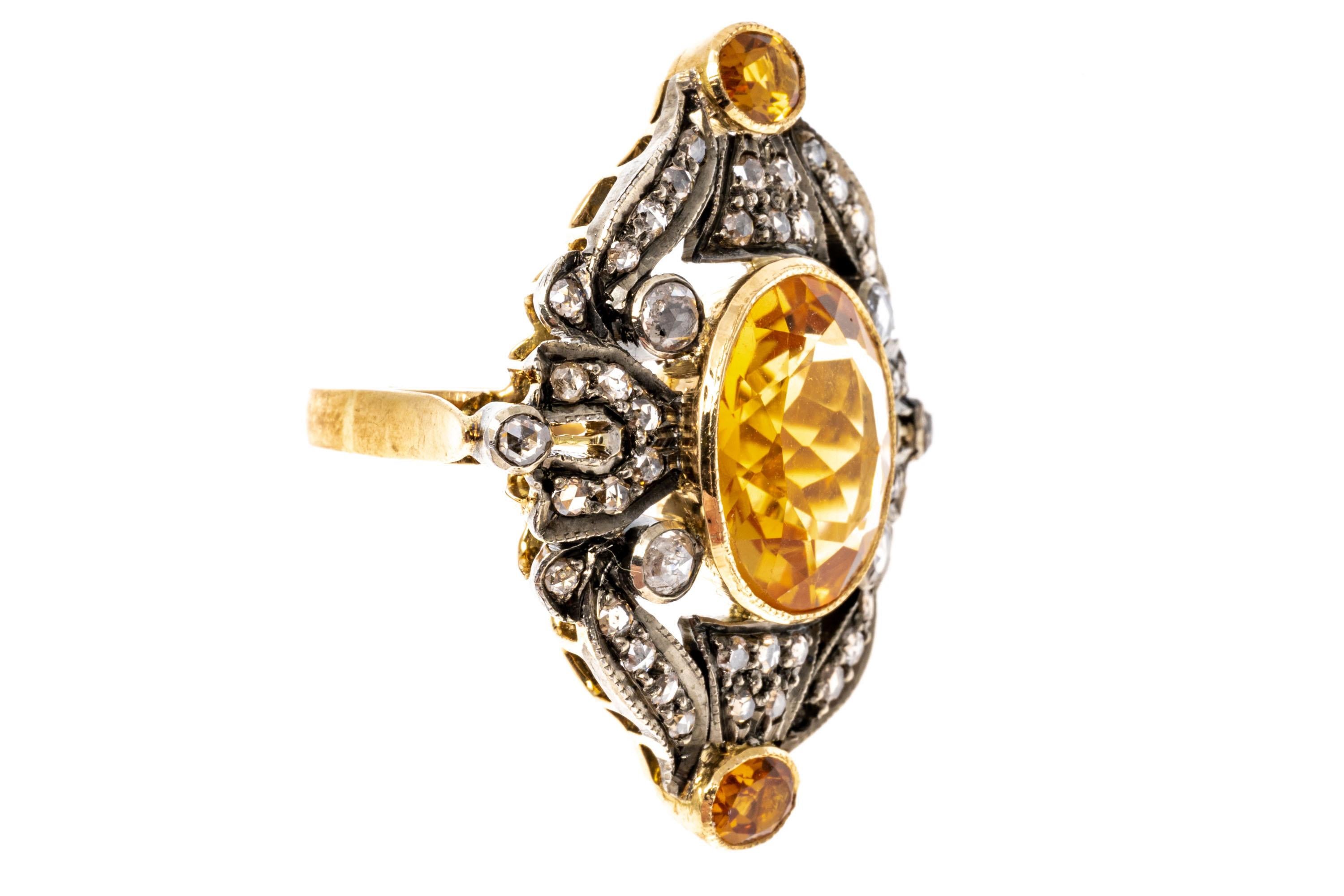 14k yellow gold and sterling silver ring. This stunning vintage ring features a center oval faceted, medium golden yellow color citrine, approximately 5.13 CTS, and bezel set. The center is framed with a decorative filigree set with rose cut faceted