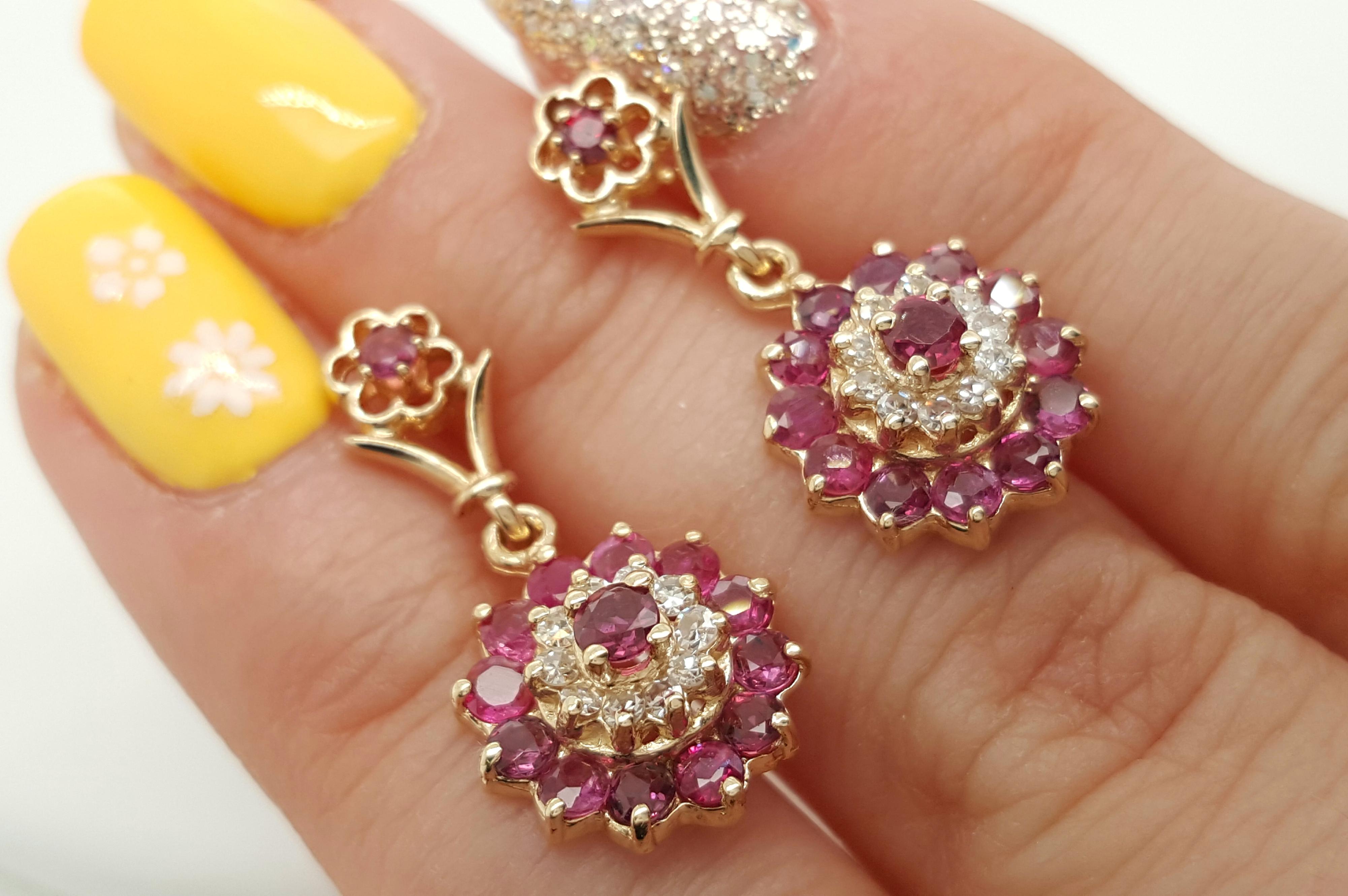 14 Karat Yellow Gold Vintage Style Diamond and Ruby Double Halo Earrings. Theses vintage inspired earrings feature round rubies and full cut diamonds in a classic double halo suspended from a tapered post with a feminine flower motif.  Completed by