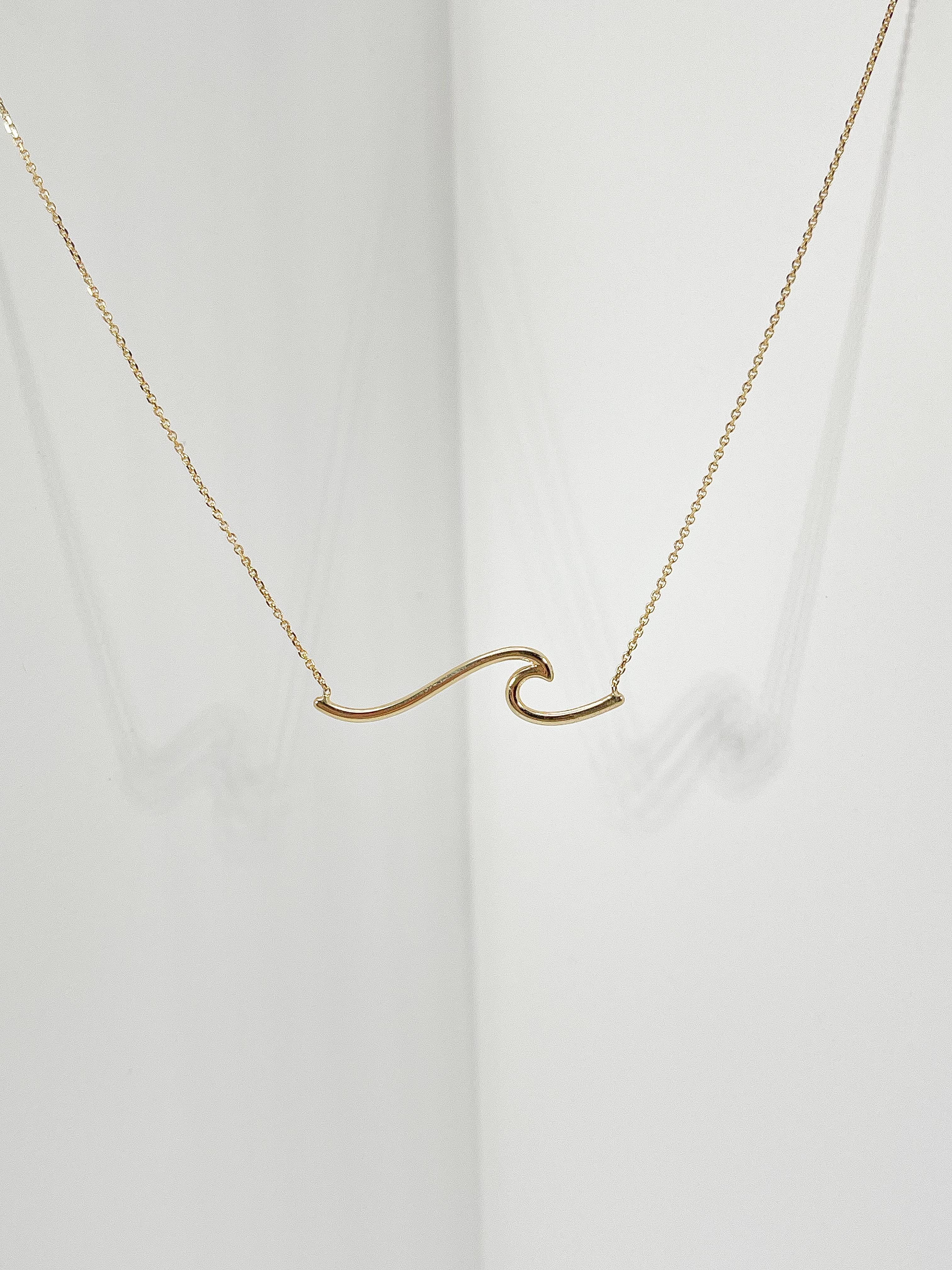 Collier à vagues en or jaune 14k. La vague mesure 7,7 x 30,3 mm, la longueur du collier est de 18 pouces, le fermoir s'ouvre et se ferme à l'aide d'un mousqueton et le poids total est de 2,37 grammes. 