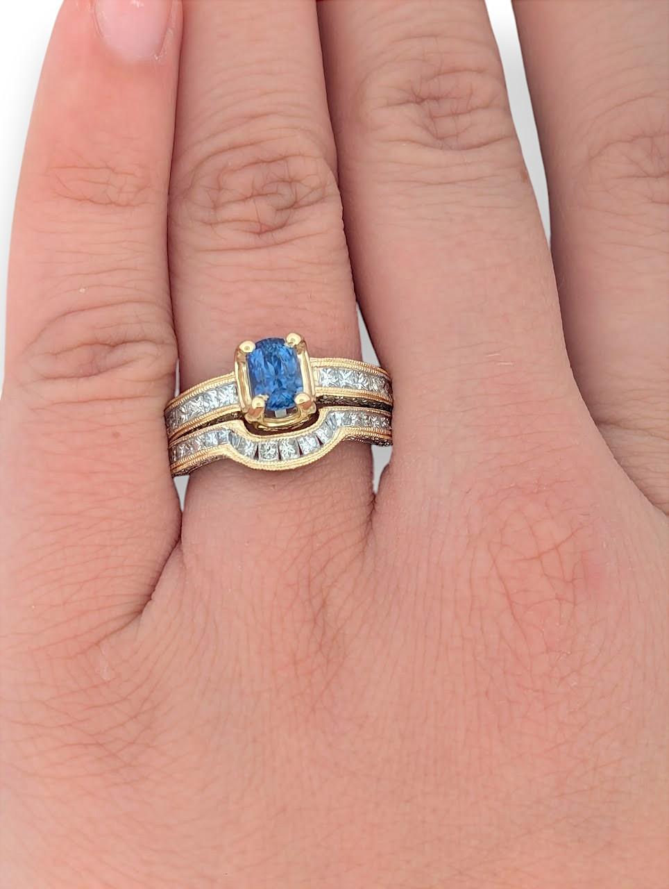 Esta exquisita alianza de oro amarillo de 14 quilates presenta una cautivadora piedra central de tanzanita de 1,25 quilates, rodeada elegantemente por diamantes naturales de 1,52 quilates en una mezcla de tallas redonda y princesa. La rica tanzanita