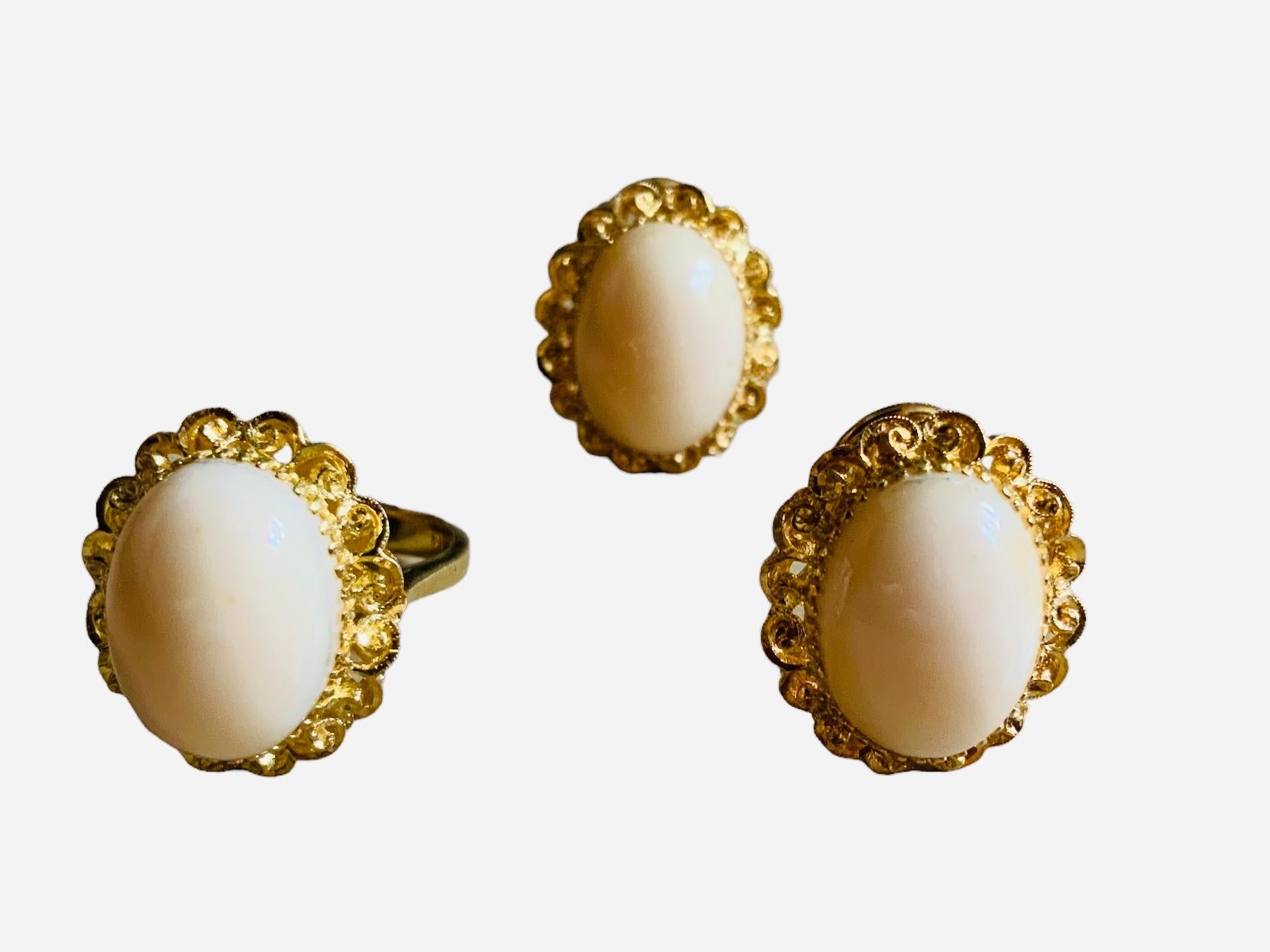 This is a White Coral Set of earrings and ring. It depicts three cabochon oval shaped white corals ( approximately 16 x 12 mm ) mounted in 18K yellow gold shaped as flowers petals earrings and ring for a total weight of 22.4 grams. The earrings have