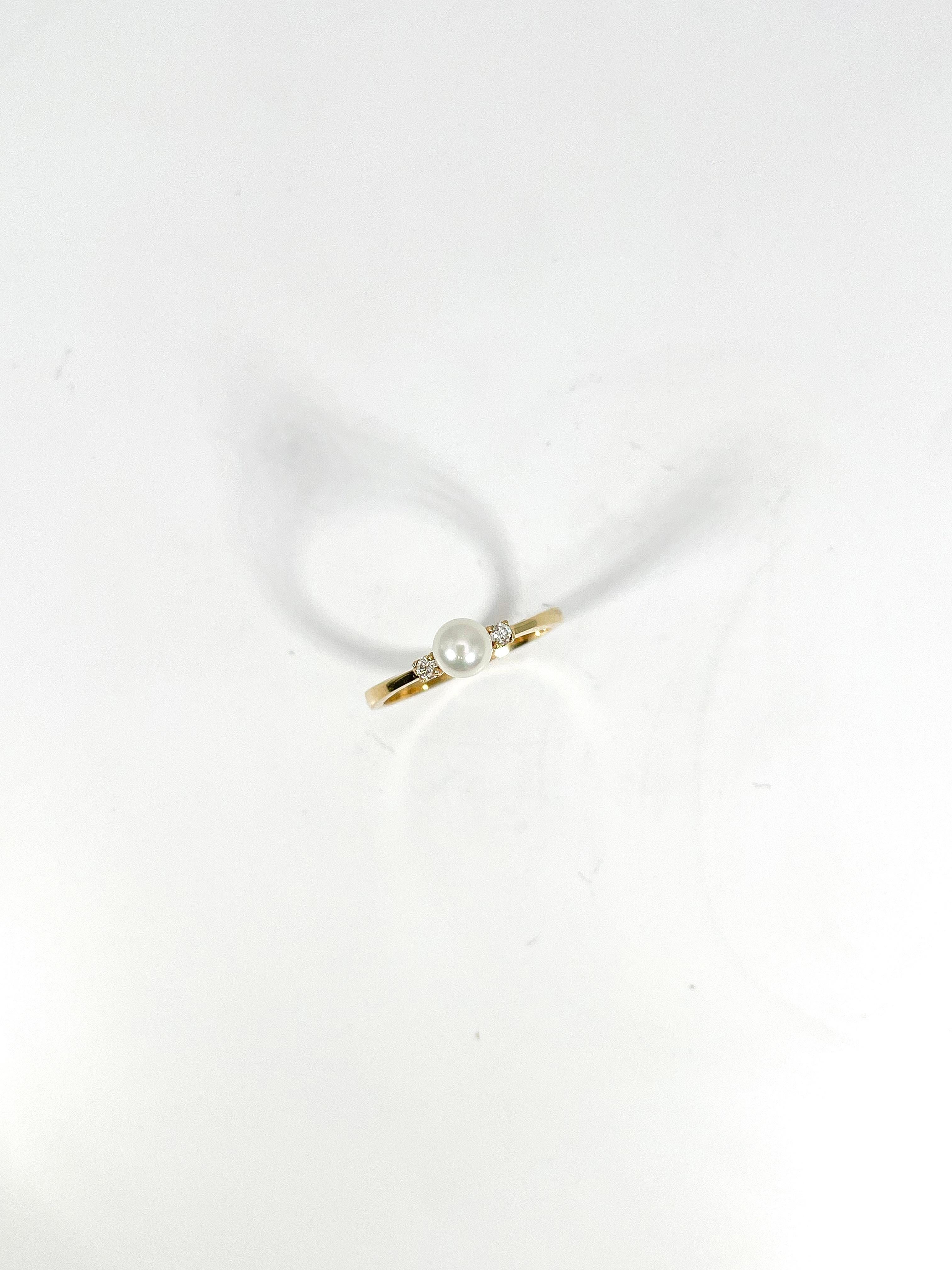 14k yellow gold white pearl and diamond ring. The width of this ring is 5 mm, the ring size is 6 1/4, both diamonds on either side of the pearl are both round, and it has a total weight of 1.9 grams