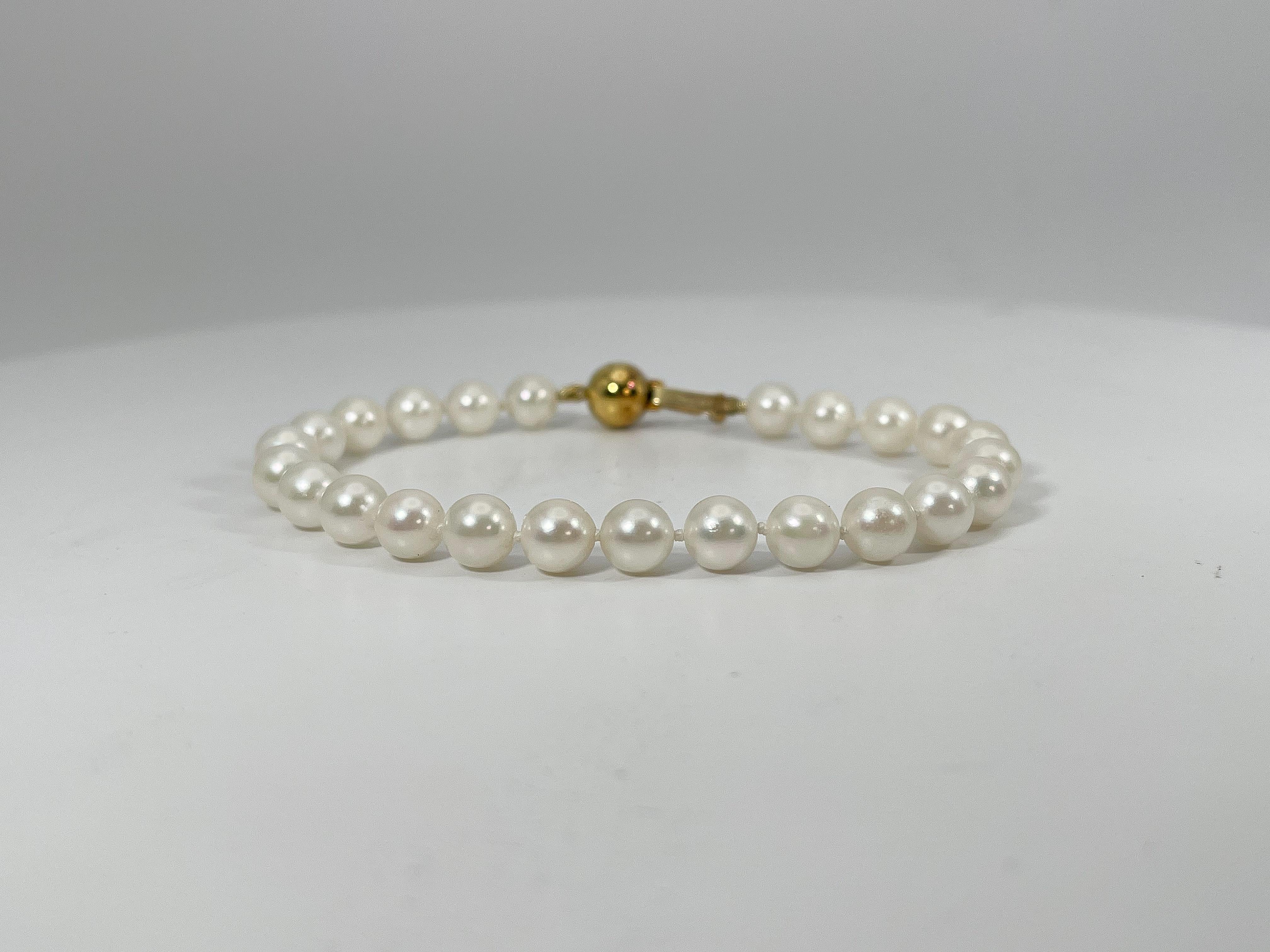 Bracelet de perles blanches en or jaune 14k. Ce bracelet est doté d'un fermoir en perles qui s'ouvre et se ferme, sa longueur est de 7 pouces, sa largeur est de 6,5 mm et son poids total est de 11,2 grammes.