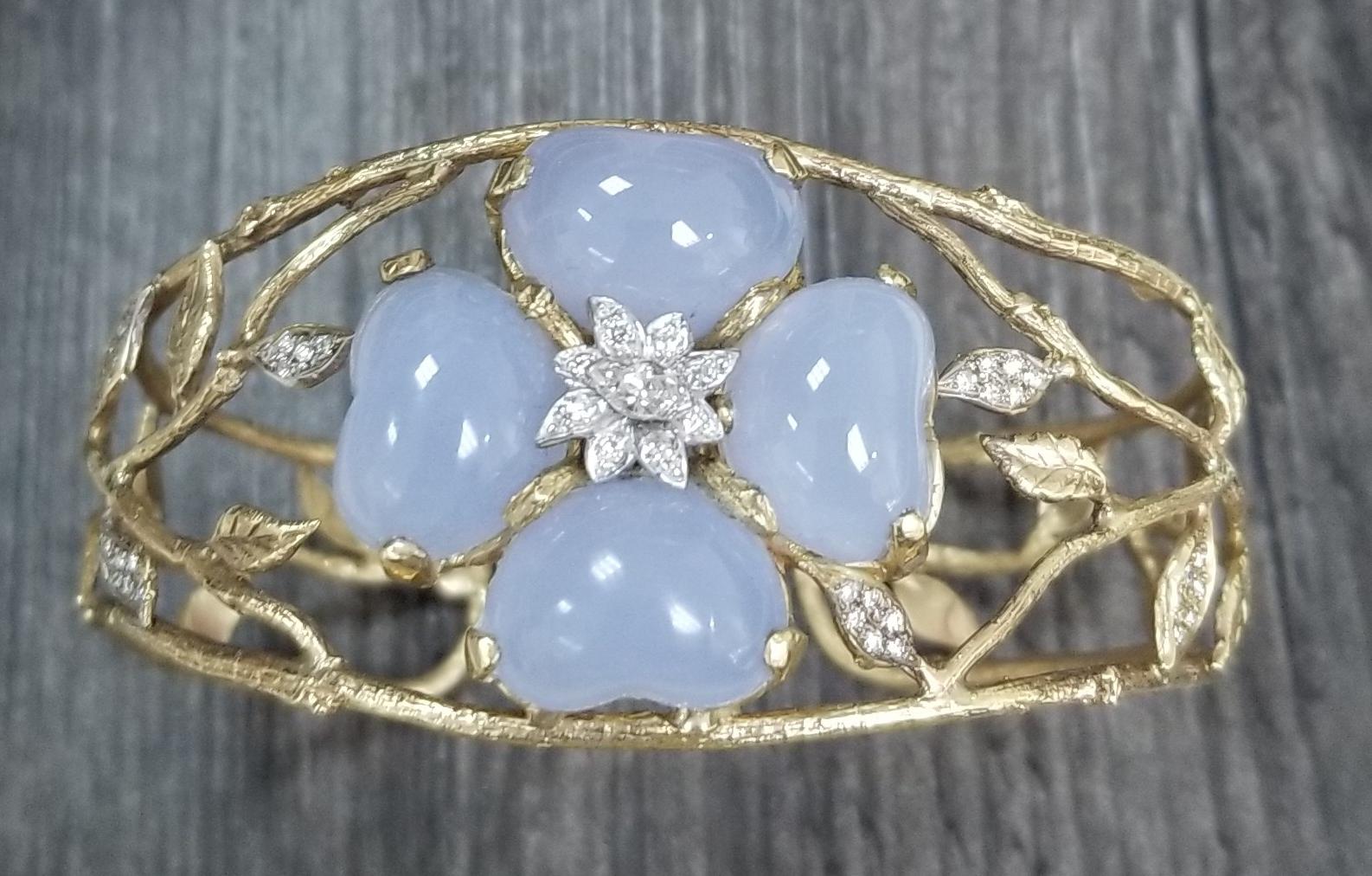 14k yellow gold with 4 heart shape cut cabochon Blue Chalcedony weighing 29.05cts. and 28 round full cut diamonds weighing .28pts. and 1 marquise cut diamond weighing .13pts. set in a hand made 