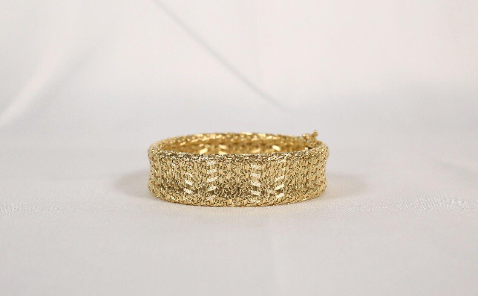 Ce bracelet exquis en or jaune 14 carats présente une maille tissée complexe, créant une sensation de luxe et de légèreté. Le savoir-faire artisanal est évident dans le motif d'entrelacs détaillé, offrant à la fois durabilité et élégance. D'une