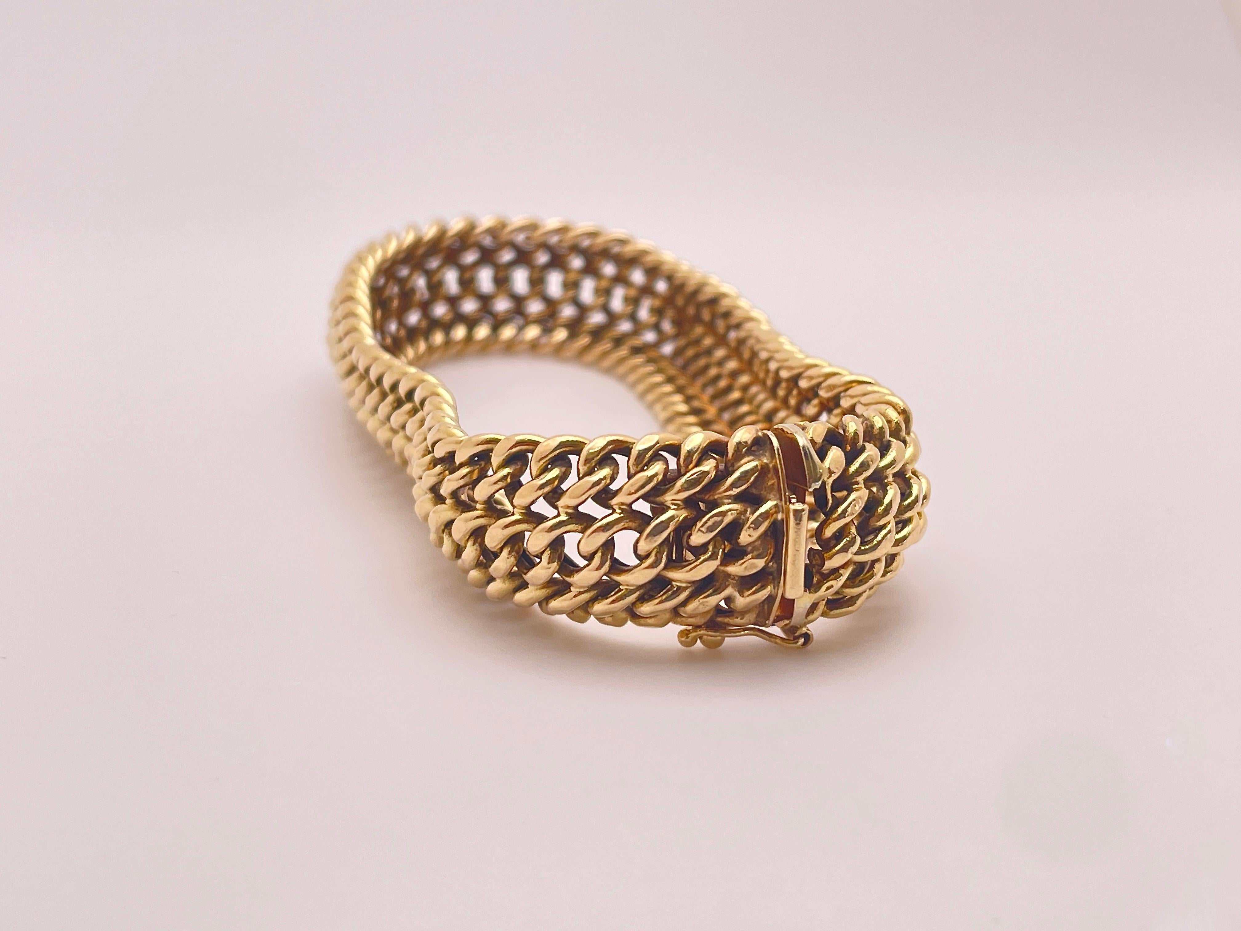Un bracelet unique en or jaune 14 carats, fait à la main, vers les années 1960. Cette pièce présente un magnifique design de mailles entrelacées qui confère au bracelet souplesse et élégance. Le fermoir porte la mention 