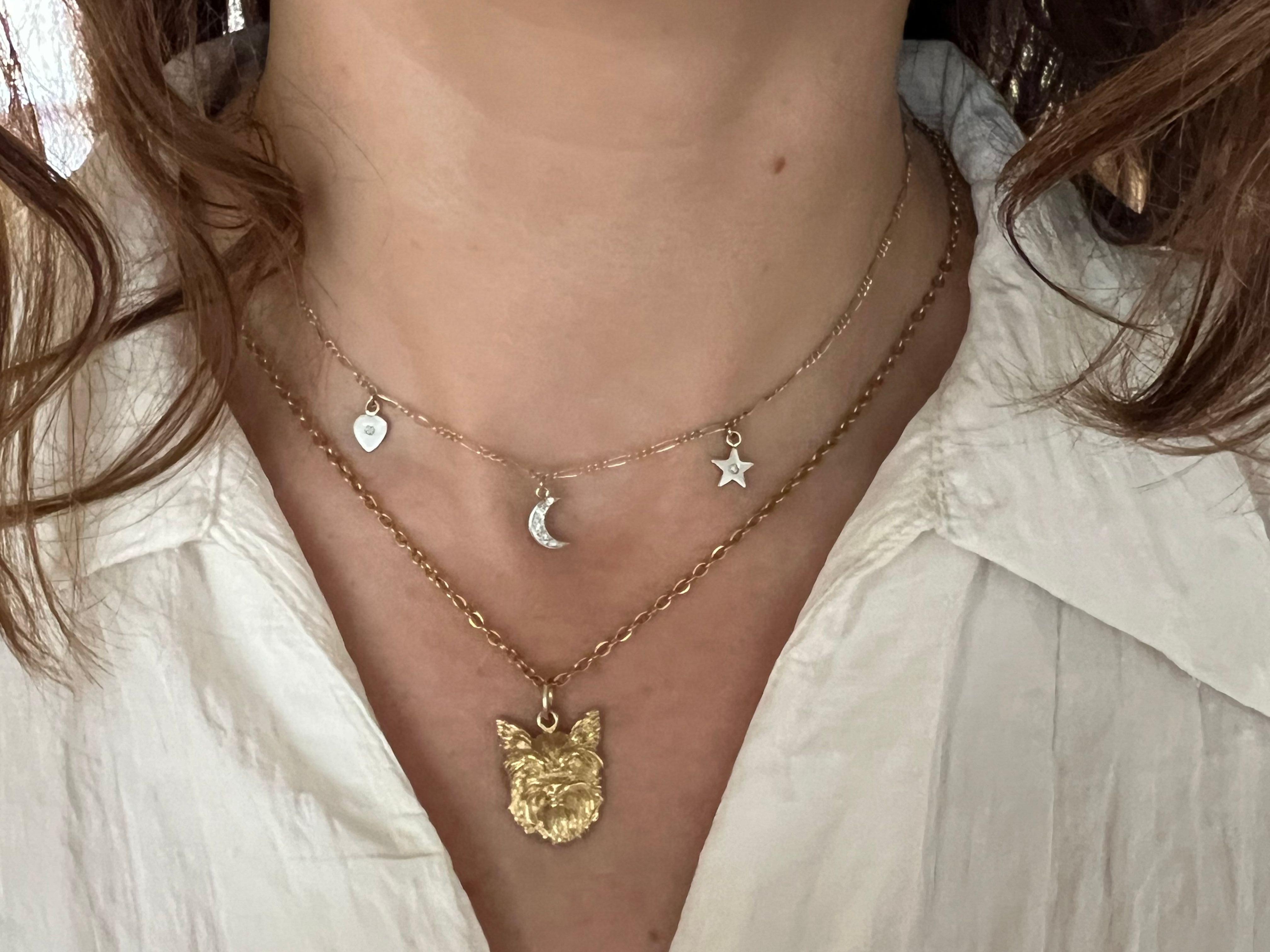 This exquisite pendant, crafted from 14k yellow gold, features a meticulously detailed depiction of a Yorkshire Terrier's head. The intricate design captures the adorable and distinctive features of the beloved Yorkie, from its expressive eyes to