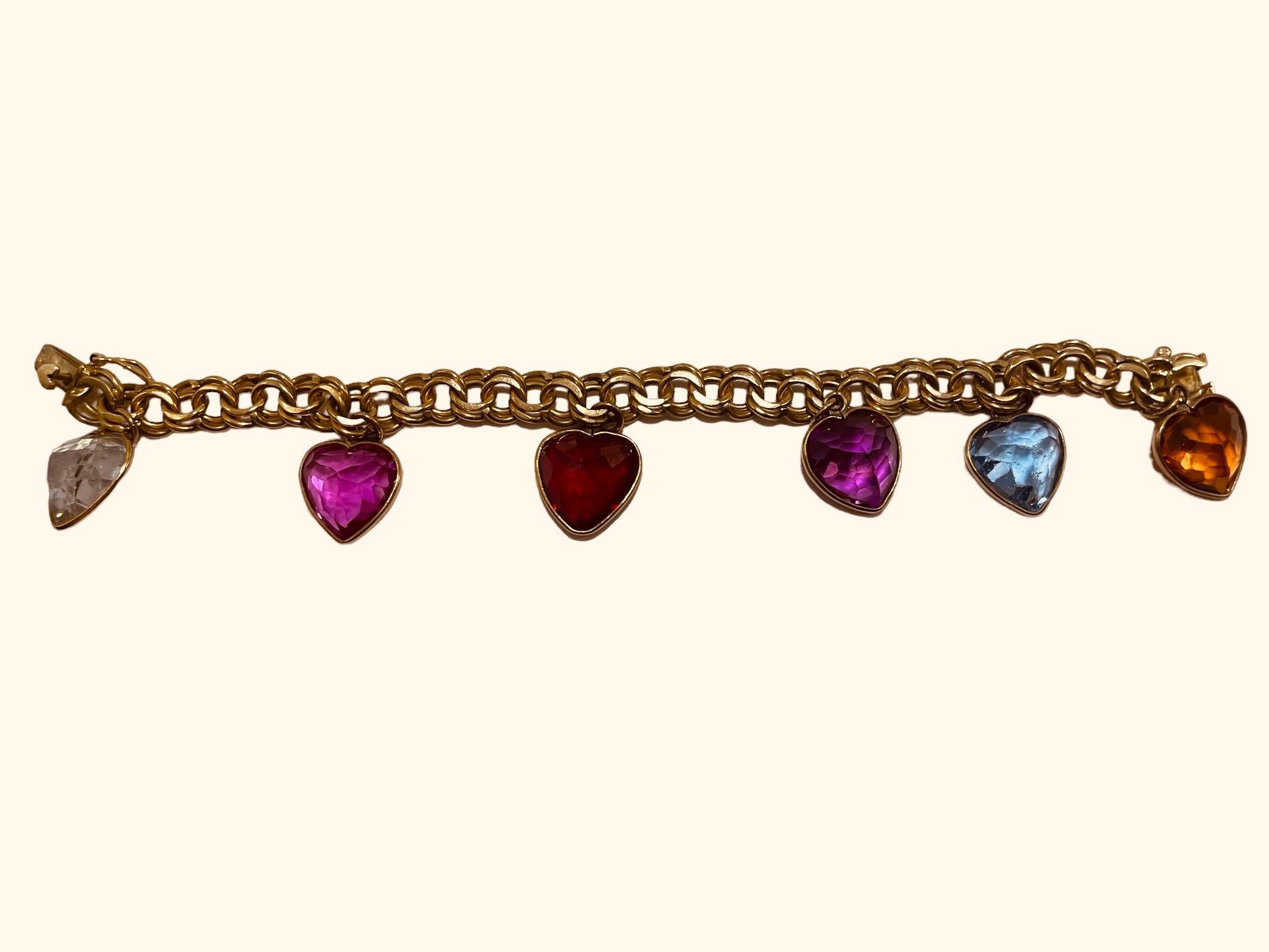 This is a 14K yellow gold Open Chino Link bracelet with charms. It depicts double rings link bracelet with seven puffy Zircon stone hearts charms framed in gold. The colors of the hearts are light green, pink, red, purple, light blue and