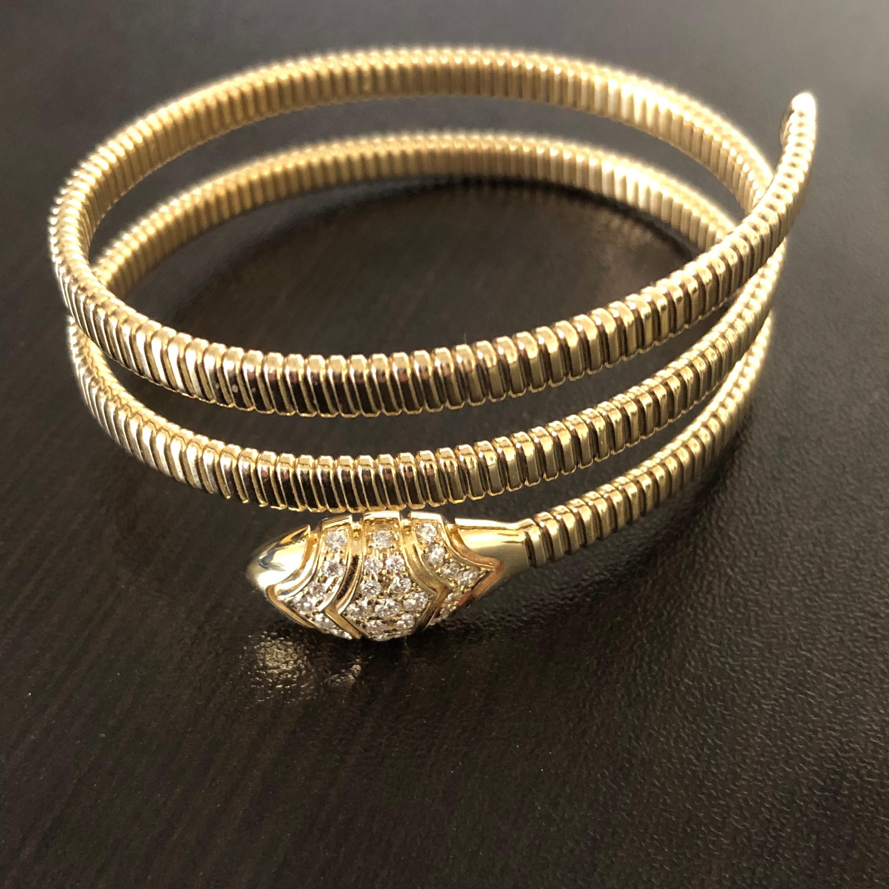 Spiral diamond bangle set in 14K yellow gold. This flexible bangle weighs a total of 0.65 carats. The color of the stones is G, the clarity is SI1. This Italy made piece is available in 14K, 18K rose gold.