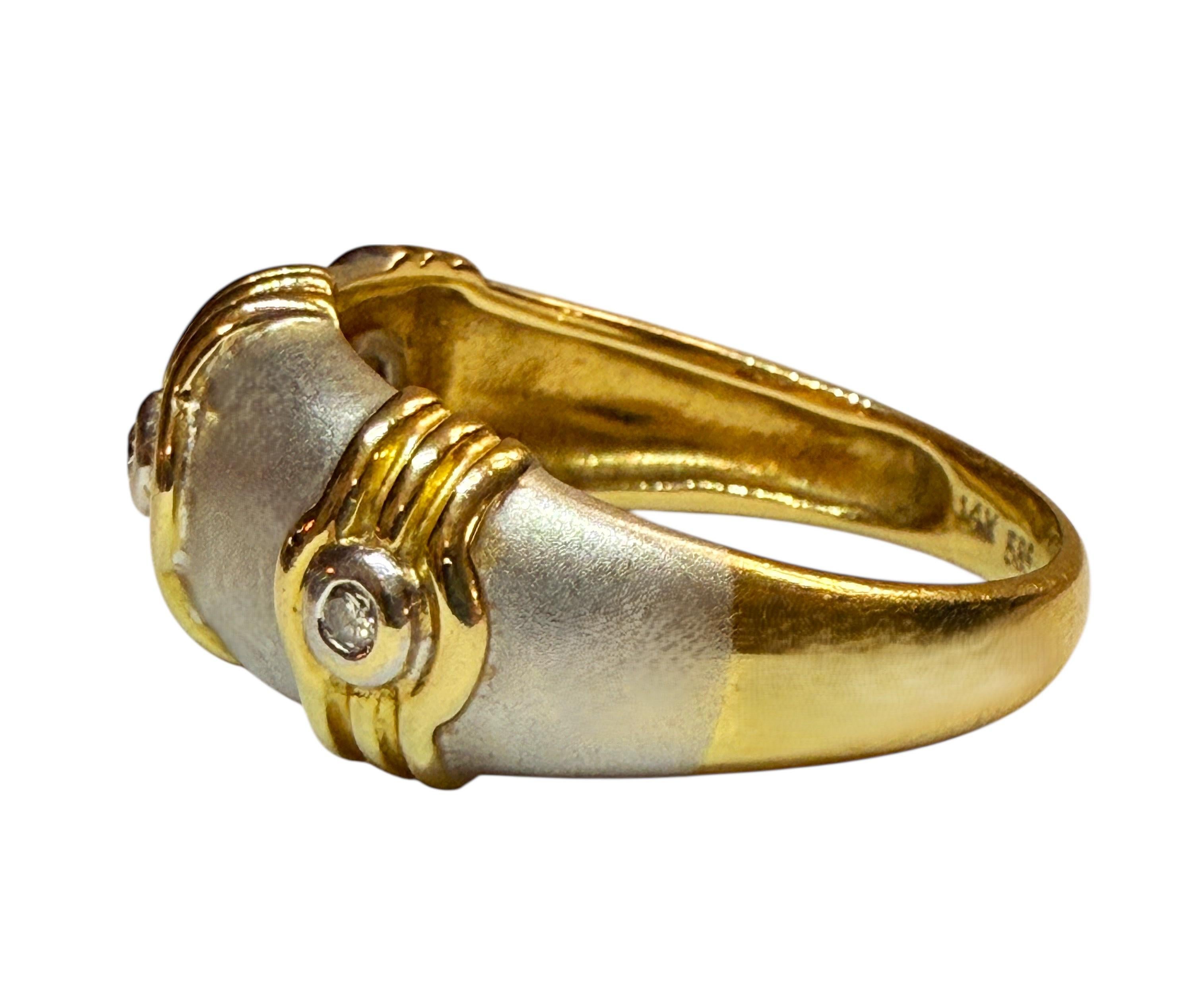 Adoro questo anello.  È un design fantastico e puoi indossarlo con qualsiasi cosa.  Porta un anello a fascia a un livello così unico e lusinghiero.  L'anello è in oro bianco e giallo e presenta 3 stazioni decorative con un diamante taglio brillante