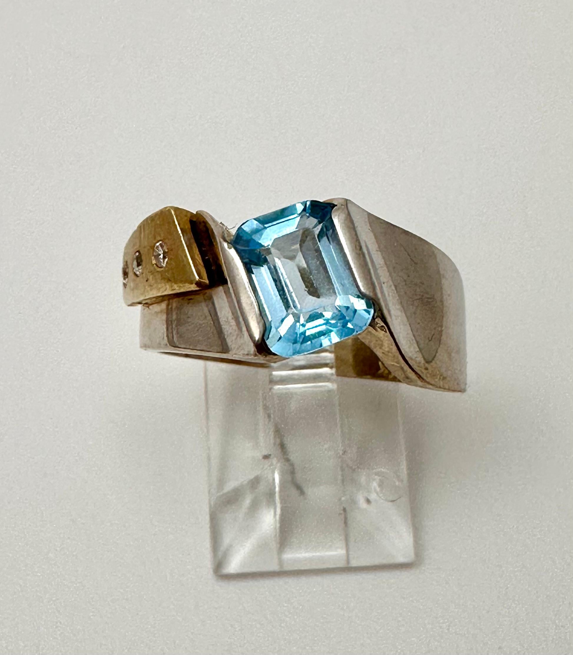 14k Yellow/White Gold 6mm x 8mm Emerald Cut Blue Topaz 3 round Diamonds
Ring Size  7 1/2

This stunning 14k yellow and white gold ring features a beautiful emerald cut blue topaz as the main stone, with a total of 3 diamonds. The rectangular shape